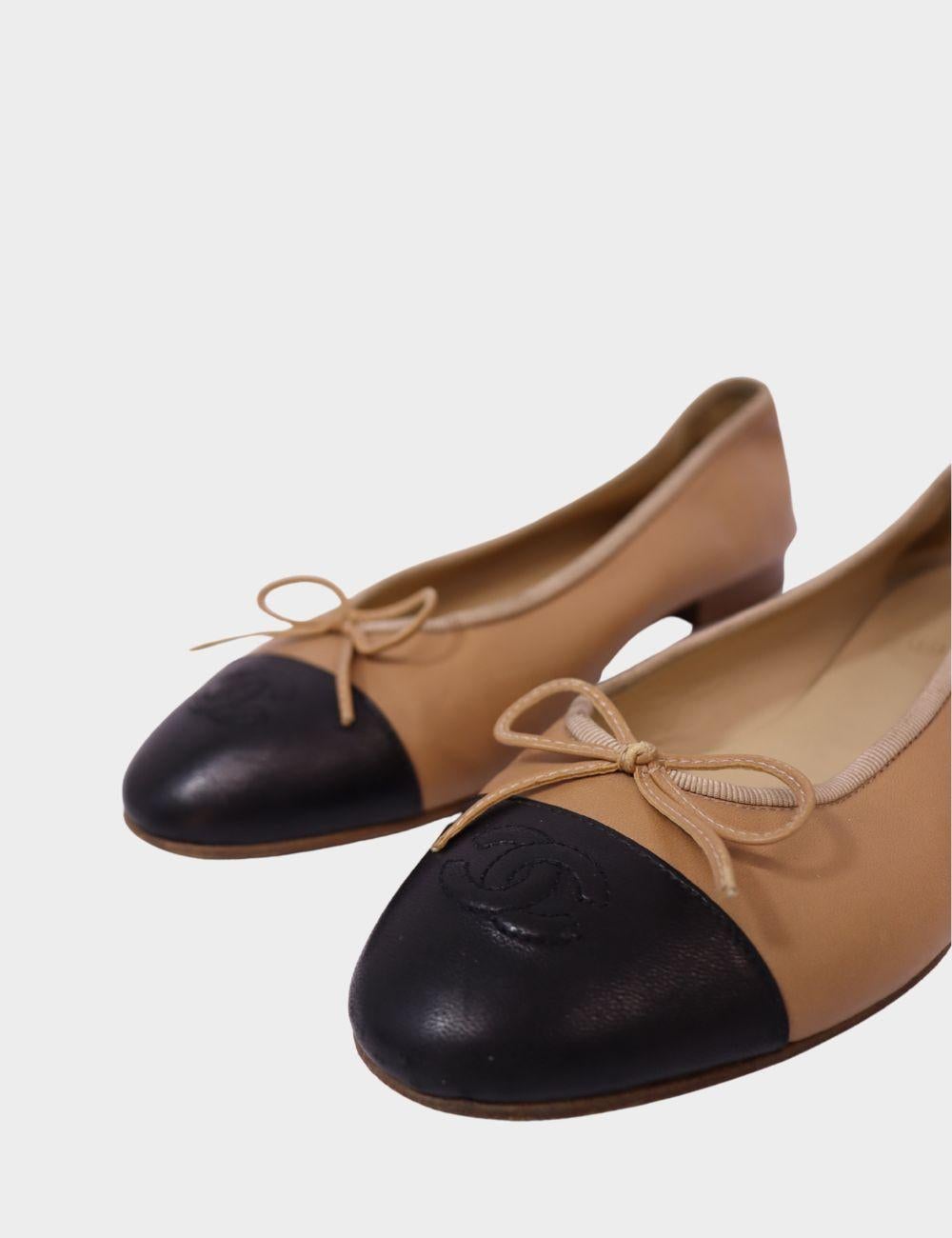 Timeless elegance meets everyday comfort with these iconic Chanel ballet flats. Crafted from smooth beige leather with contrasting black leather cap toes, these flats feature delicate bow detailing and the signature embossed Chanel logo on the toe.