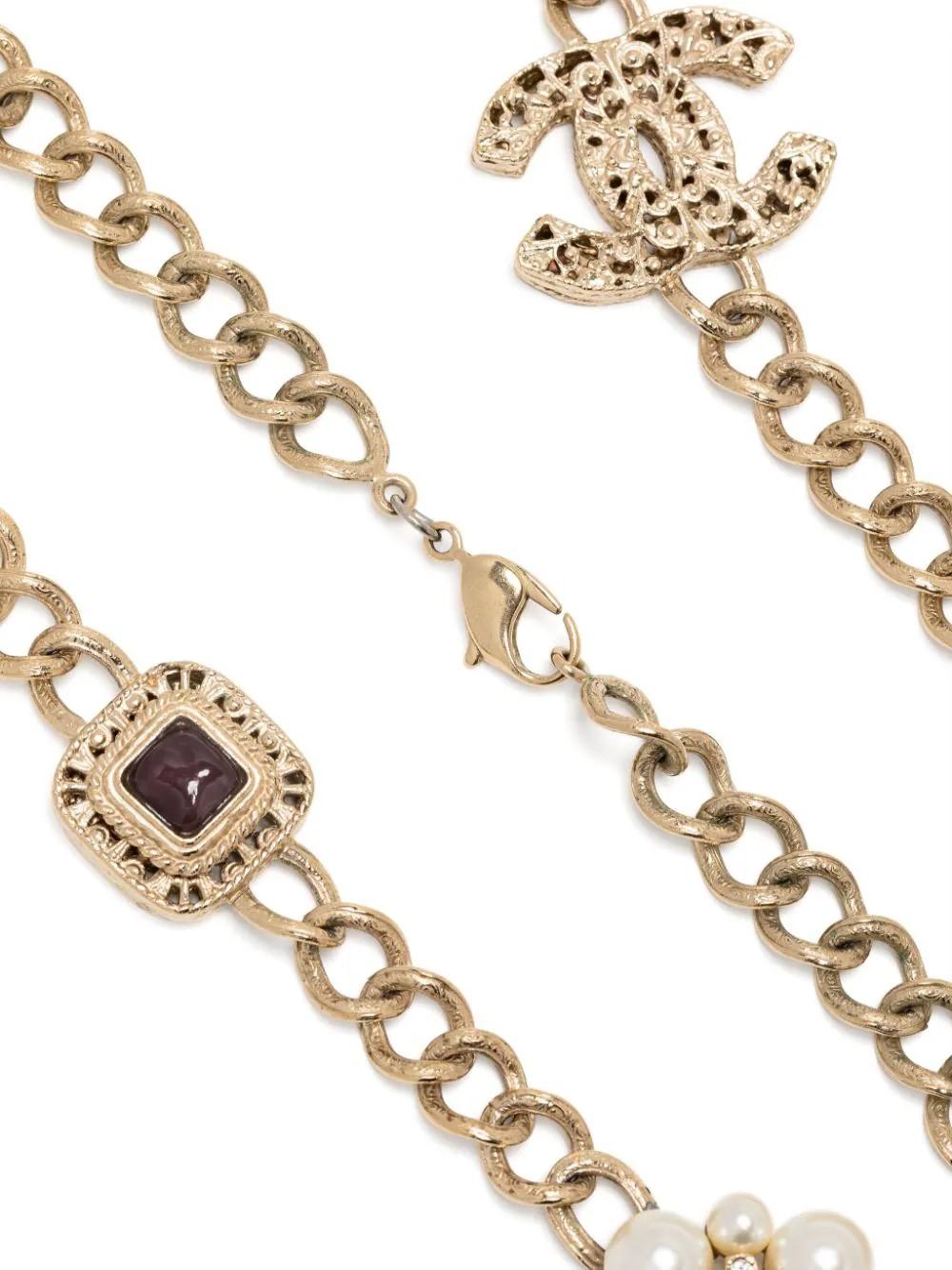 This vintage Chanel necklace features gemstones and the iconic interlocking CC logo. Crafted with gold pleating, it exudes timeless elegance. Elevate any outfit with this statement piece. 

•Gold-tone
•Gold plated
•Cabochon gemstone
•Faux-pearl