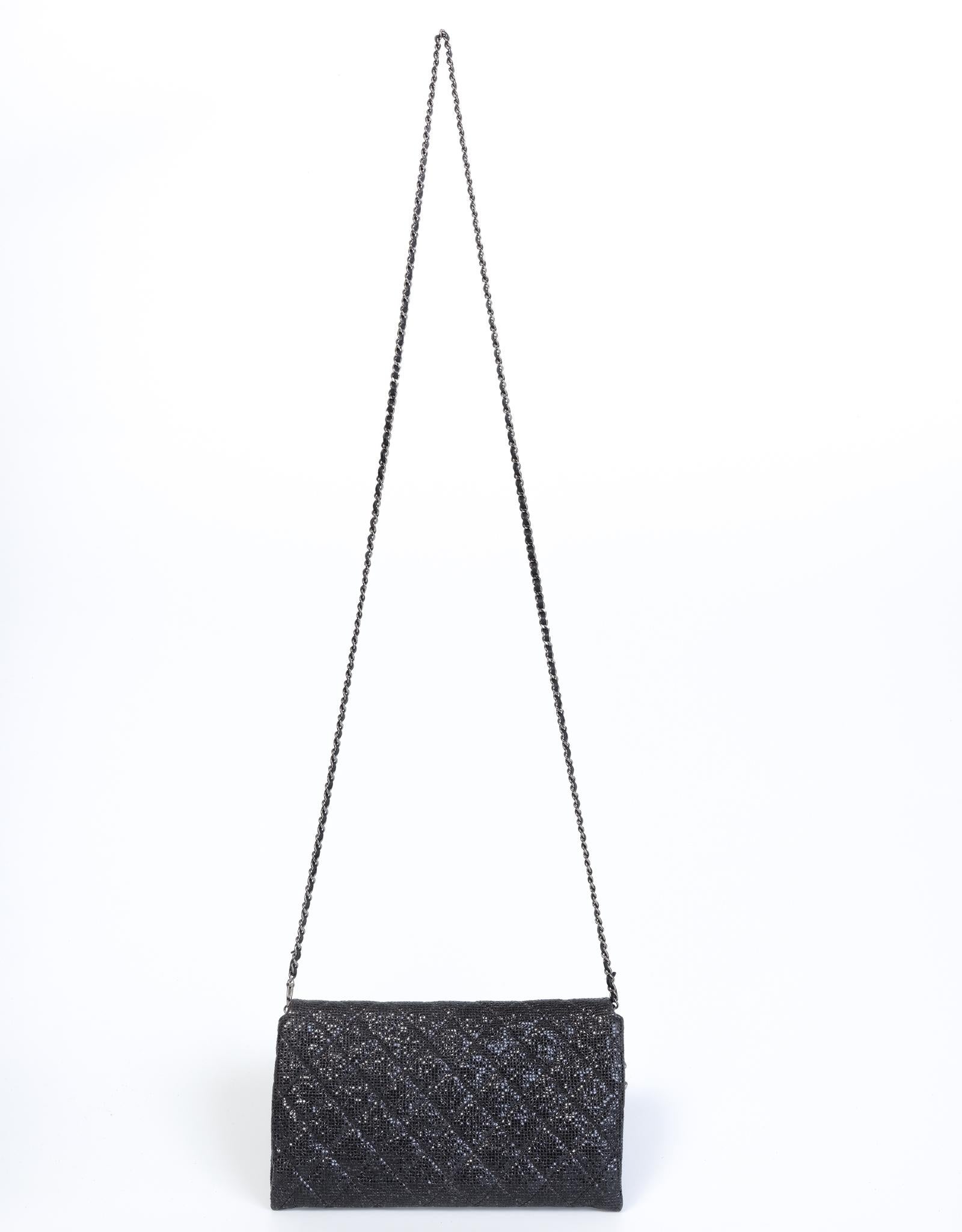 It was available to select Chanel customers during the December 2014 holiday season. Black metallic quilted material with dark silver CC logo charm and a dark sliver toned chain interlaced with leather with a 25.5