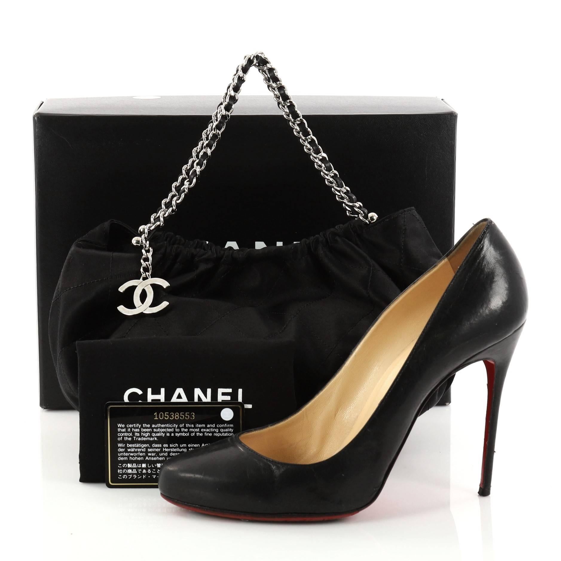 This authentic Chanel CC Charm Shoulder Bag Quilted Satin Mini showcases a sleek style that complements any look. Crafted from black satin in Chanel's iconic diamond quilted pattern, this bag features a feminine silhouette, dual woven-in leather