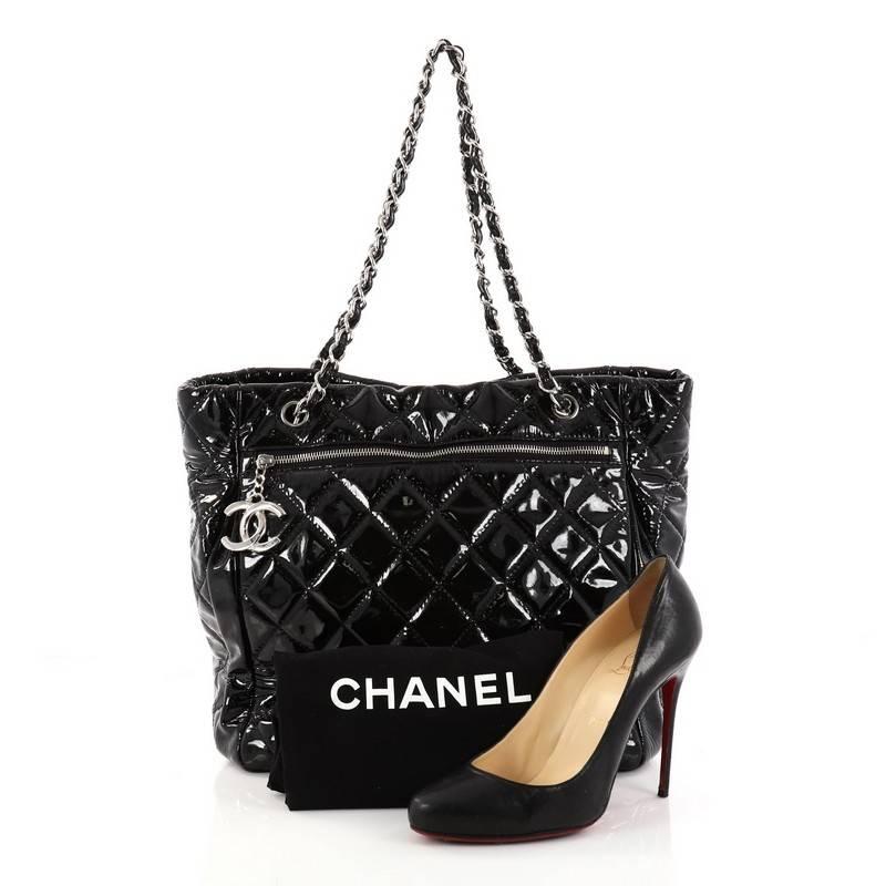 This authentic Chanel CC Charm Tote Quilted Patent Vinyl Large showcases an elegant and timeless design made for Chanel lovers. Crafted in black diamond quilted patent vinyl, this tote features woven-in leather chain straps, oversized CC silver