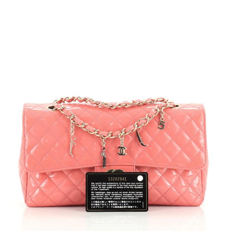 This Chanel CC Charms Flap Bag Quilted Patent Medium, crafted in pink quilted patent leather, features a woven-in chain strap, medallion CC charm, and gold-tone hardware. Its CC turn-lock closure opens to a black leather interior and displays a zip