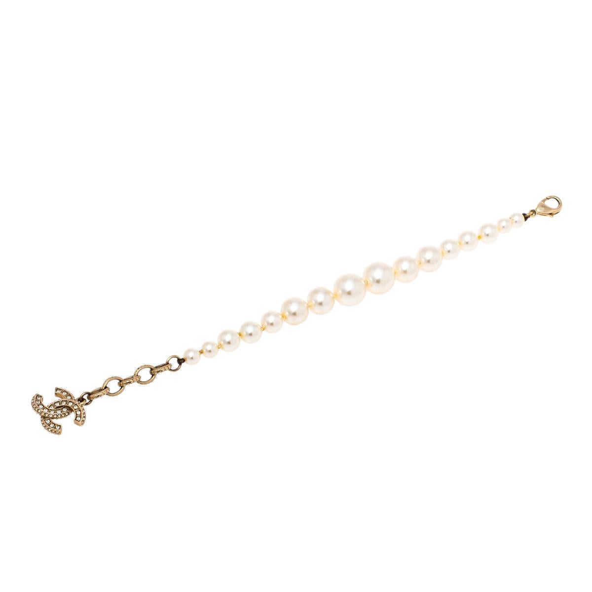 This simple and elegant bracelet from Chanel features a long strand of faux pearls and will adorn your wrist beautifully. Rendered in gold-tone metal, the bracelet is accompanied by an embellished 'CC' logo charm. This piece will become a