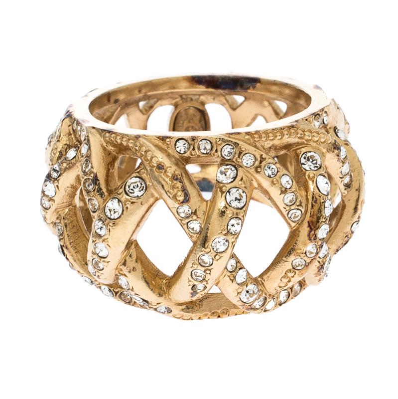 Chic and classy, there is no reason to not like this Chanel ring. Featuring a rounded silhouette, this piece comes in a gold-tone body with crisscross pattern decked with crystals. It exudes an antique appearance that looks best when styled with a