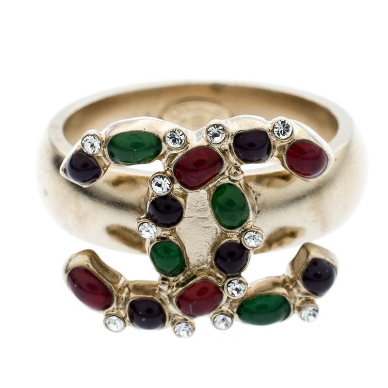 This marvelously designed ring by Chanel is so pretty you'll love having it on your finger. The gold-tone metal creation has been designed with the CC logo at the front encrusted with crystals and enamel gemstones. It is complete with hallmark