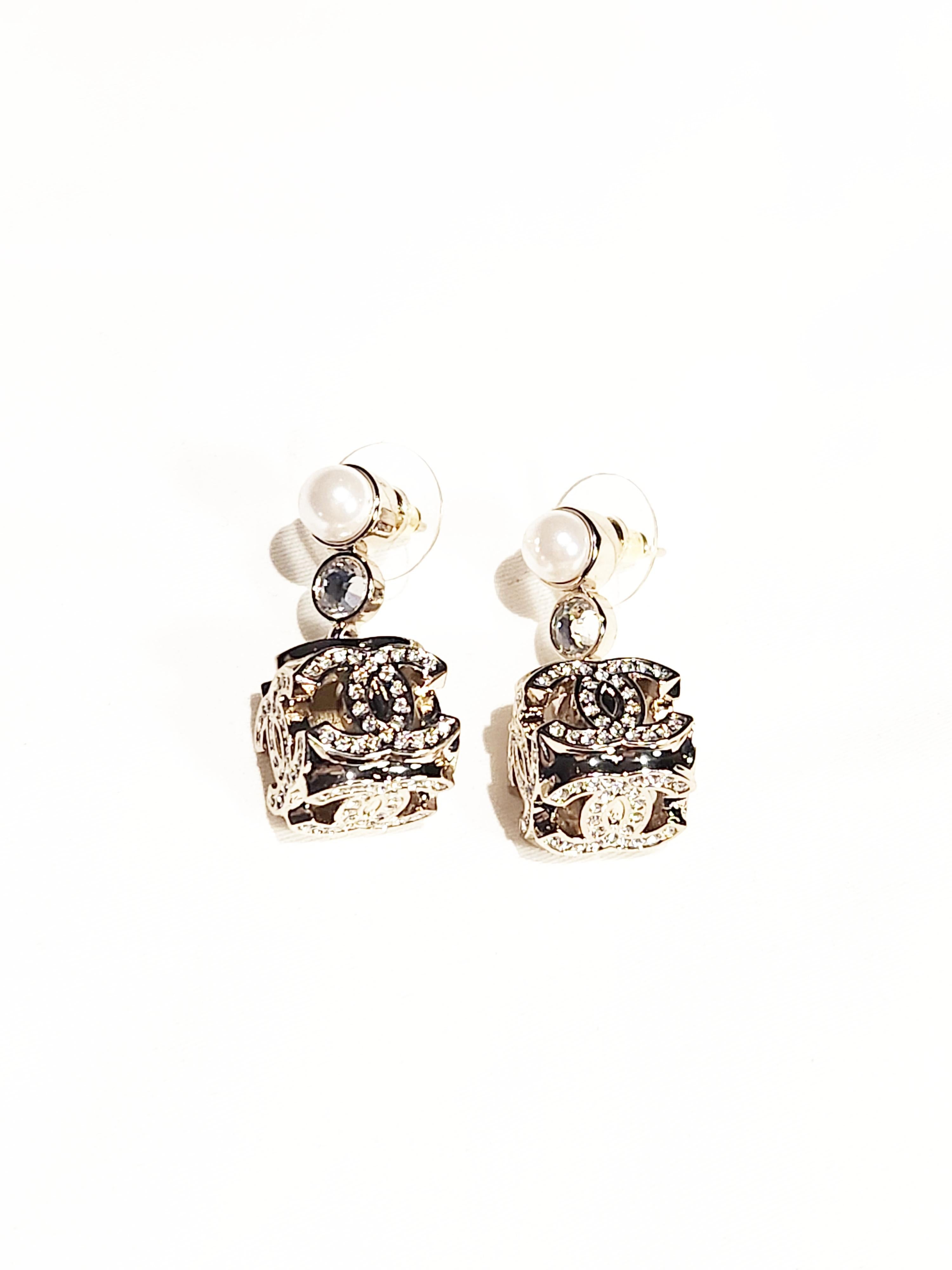 Step into the world of contemporary elegance with the Chanel Cube CC Dangling Earrings. This striking accessory combines modern design with the timeless allure of Chanel craftsmanship, creating a statement piece that effortlessly elevates your