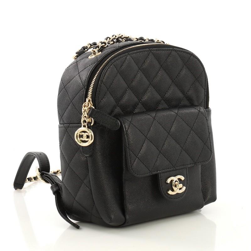This Chanel CC Day Backpack Quilted Caviar Mini, crafted from black quilted caviar, features front flap pocket with CC turn-lock closure, adjustable backpack straps, and gold-tone hardware. Its zip closure opens to a black fabric interior. Hologram