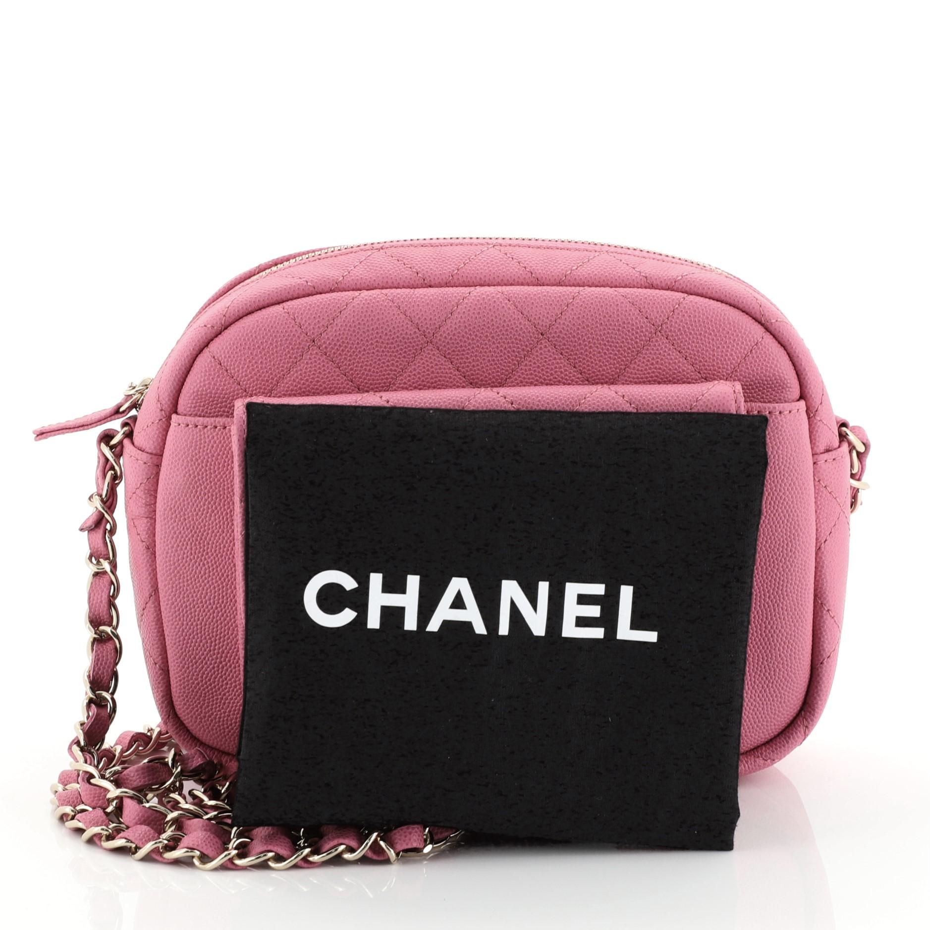 This Chanel CC Day Camera Case Quilted Caviar Medium, crafted from pink quilted caviar leather, features woven-in leather chain strap, front flap pocket with CC turn-lock closure, and gold-tone hardware. Its zip closure opens to a pink fabric