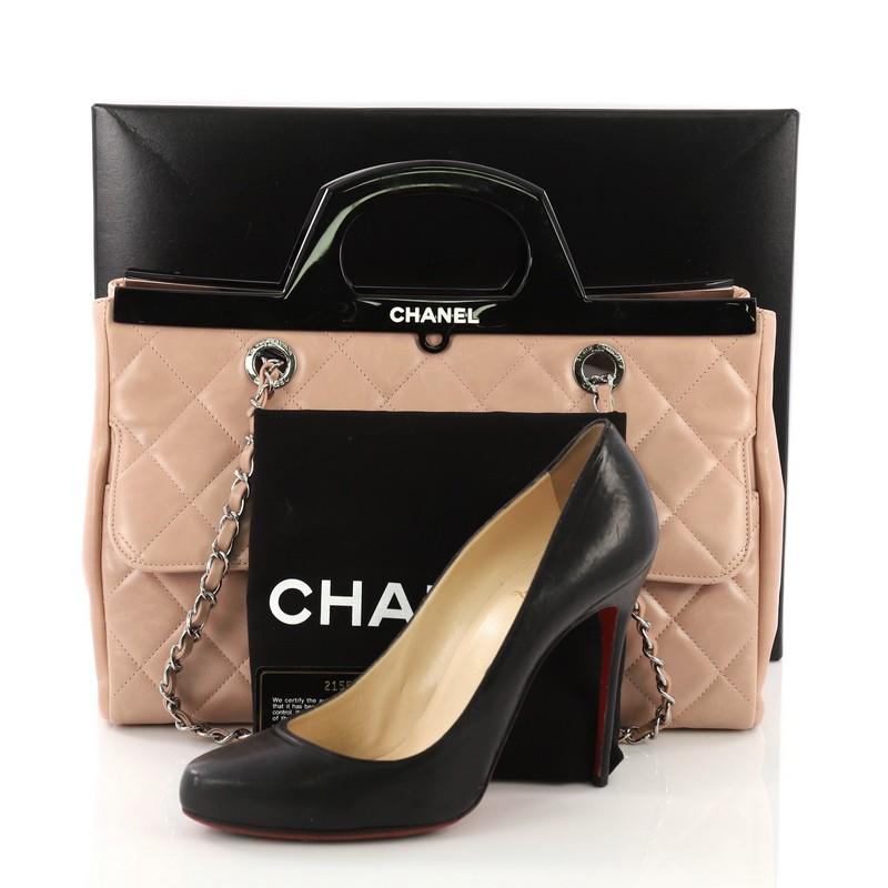 This Chanel CC Delivery Tote Quilted Glazed Calfskin Small, crafted from pink quilted glazed calfskin, features woven-in leather chain link straps, exterior flap pocket with CC turn-lock, rigid acetate plexi cut-out handle and frame, and silver-tone