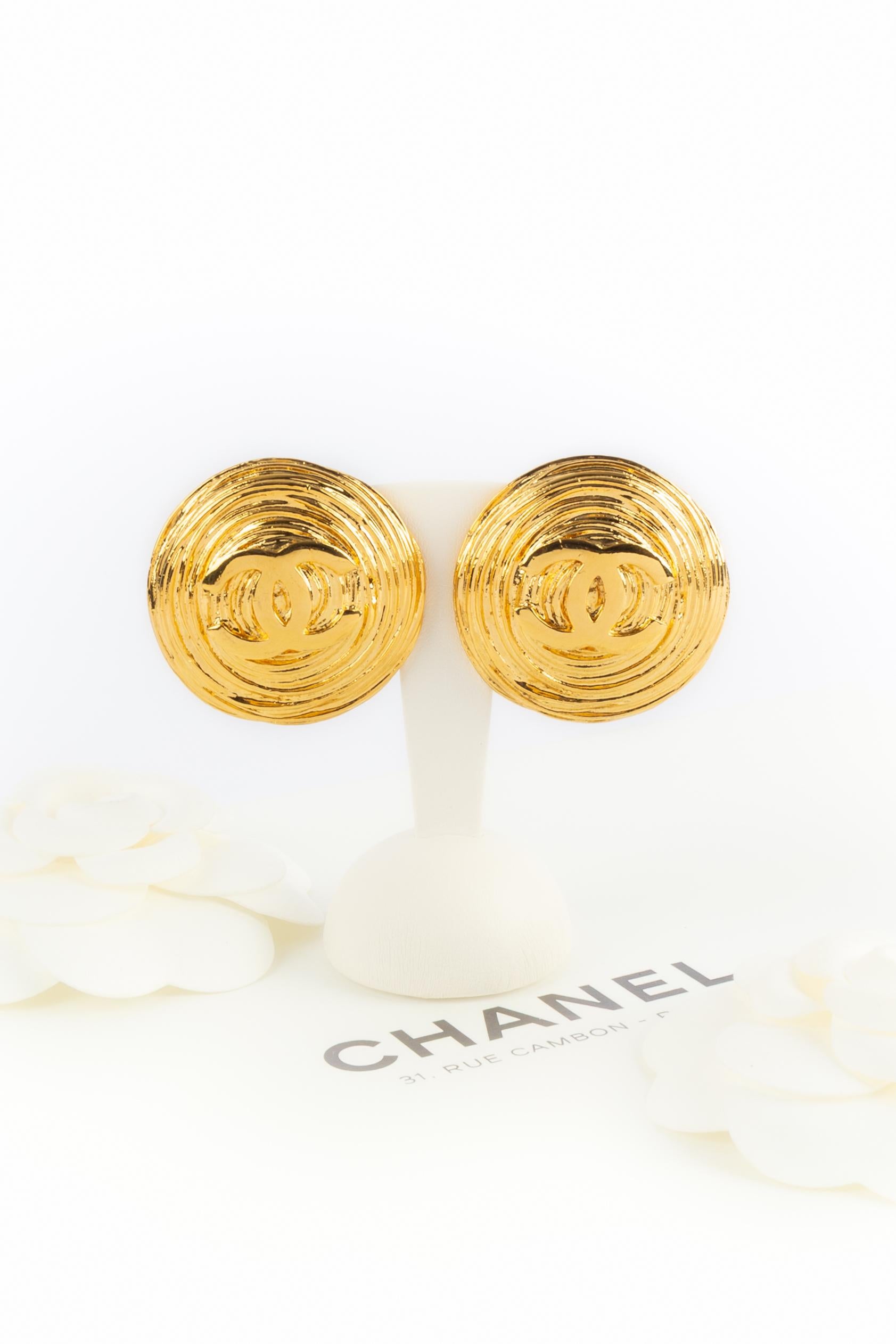 Chanel - (Made in France) Orecchini in metallo dorato con logo Chanel. Una collezione 2cc5 dei primi anni '90 sotto la direzione artistica di Karl Lagerfeld.

Condizioni:
Ottime condizioni

Dimensioni:
Diametro: 4 cm

SKU:BOB211