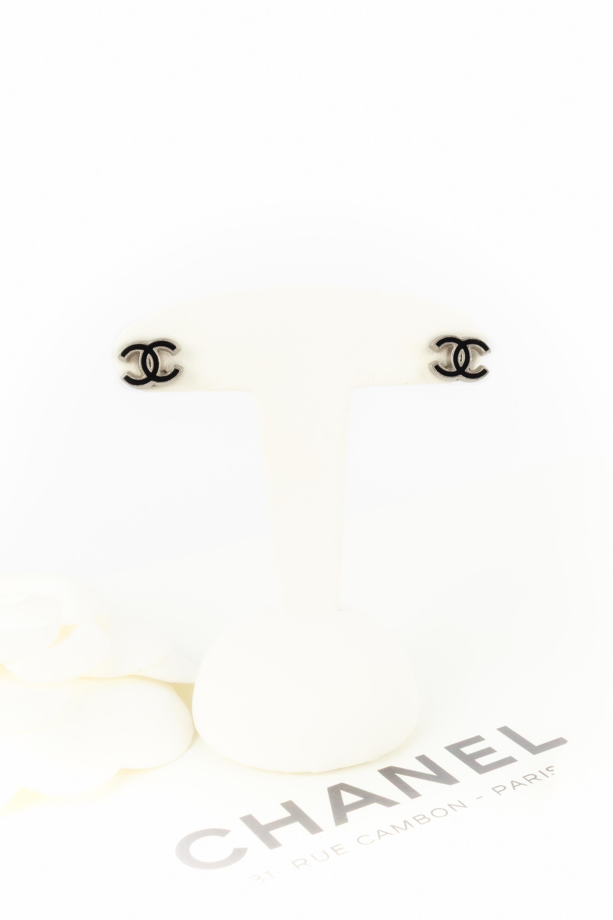 CHANEL - (Fabricado en Francia) Pendientes cc de metal plateado esmaltado en negro. Colección Primavera-Verano 2004 bajo la dirección artística de Karl Lagerfeld.

Estado:
Muy buen estado

Dimensiones:
0.6 cm x 1 cm

SKU:BOB277