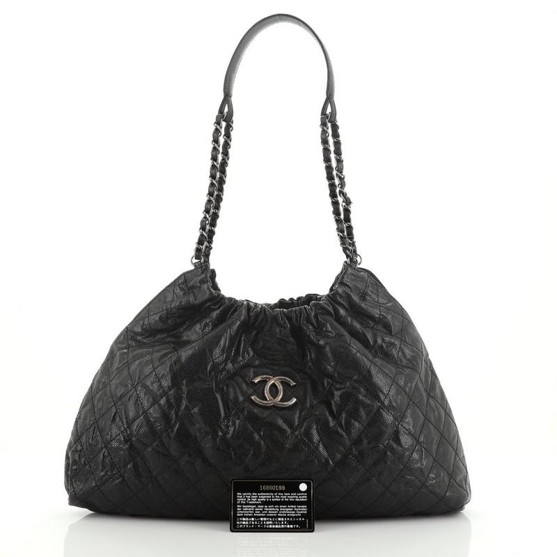 This Chanel CC Elastic Shoulder Bag Quilted Glazed Caviar Small, crafted from black quilted glazed caviar leather, features woven-in leather chain link strap with looping leather shoulder pad, aged silver Chanel CC logo at front, elasticized top