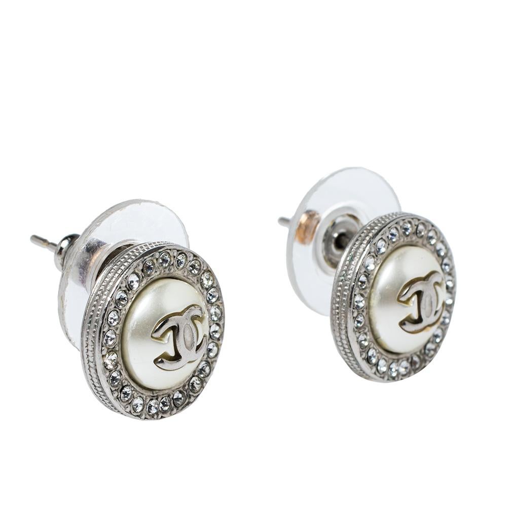 Glam up your look instantly with these stunning earrings from the house of Chanel. It features a rounded silhouette with 'CC' and faux pearl detailing at the center and surrounded by crystal embellishments. It is secured with push-lock closures.