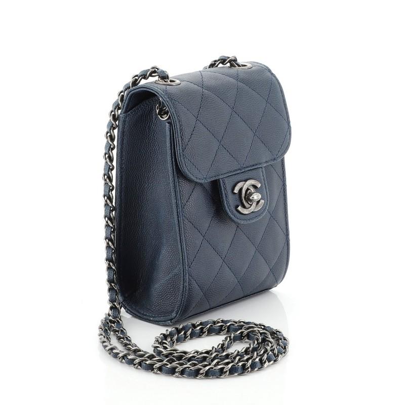 This Chanel CC Flap Phone Holder Crossbody Bag Quilted Caviar, crafted in blue quilted caviar leather, features woven-in leather chain strap, flap top, and aged silver-tone hardware. Its CC turn-lock closure opens to a blue leather interior with