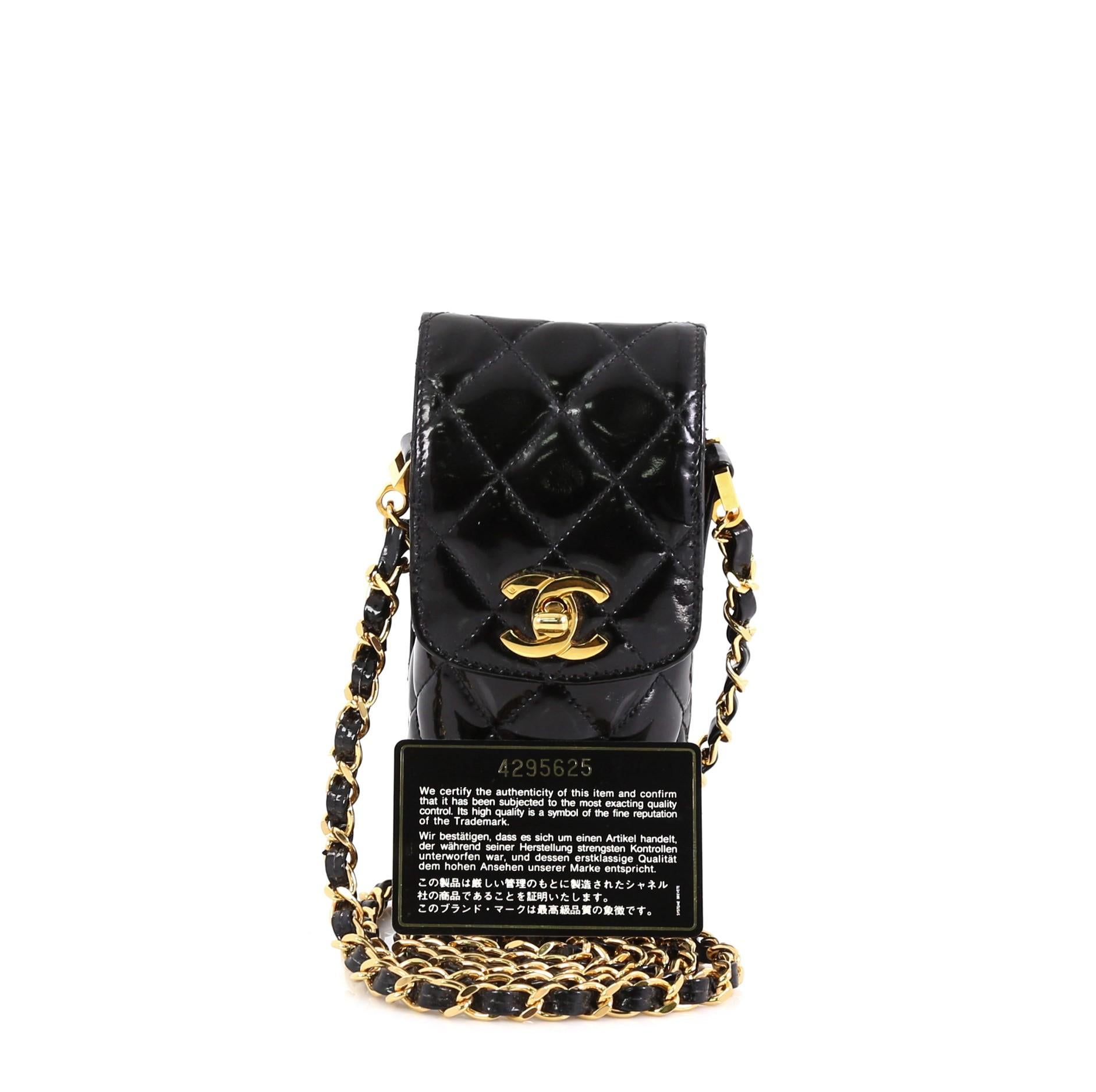 This Chanel CC Flap Phone Holder Crossbody Bag Quilted Patent, crafted in black quilted patent leather, features woven-in leather chain strap and gold-tone hardware. Its CC turn-lock closure opens to a black leather interior. Hologram sticker reads: