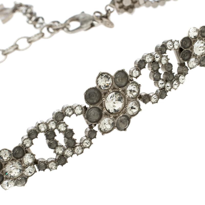 A Chanel creation, this necklace is graced with unparalleled elegance and beauty. Crafted in a choker style, this neck piece is a breathtaking assortment of crystals rendered in silver-tone metal. The length of the necklace features flower patterns,