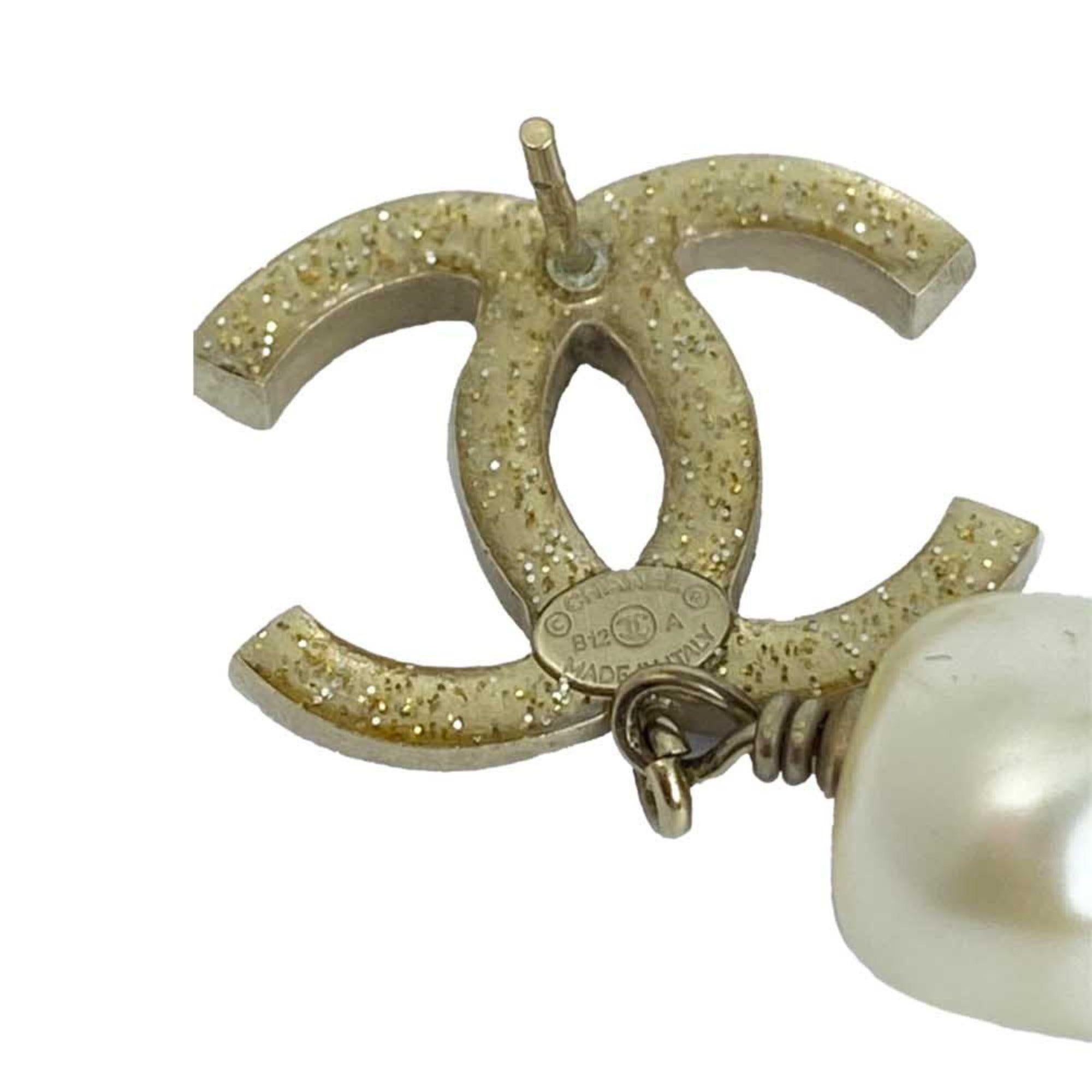 Chanel CC Glass Pearl Drop Earrings feature the classic CC emblem in gold tone hardware, embellished with dazzling diamantes and hanging glass pearls. Pale gold tone hardware with black, grey and silver diamantes; hanging glass pearls.