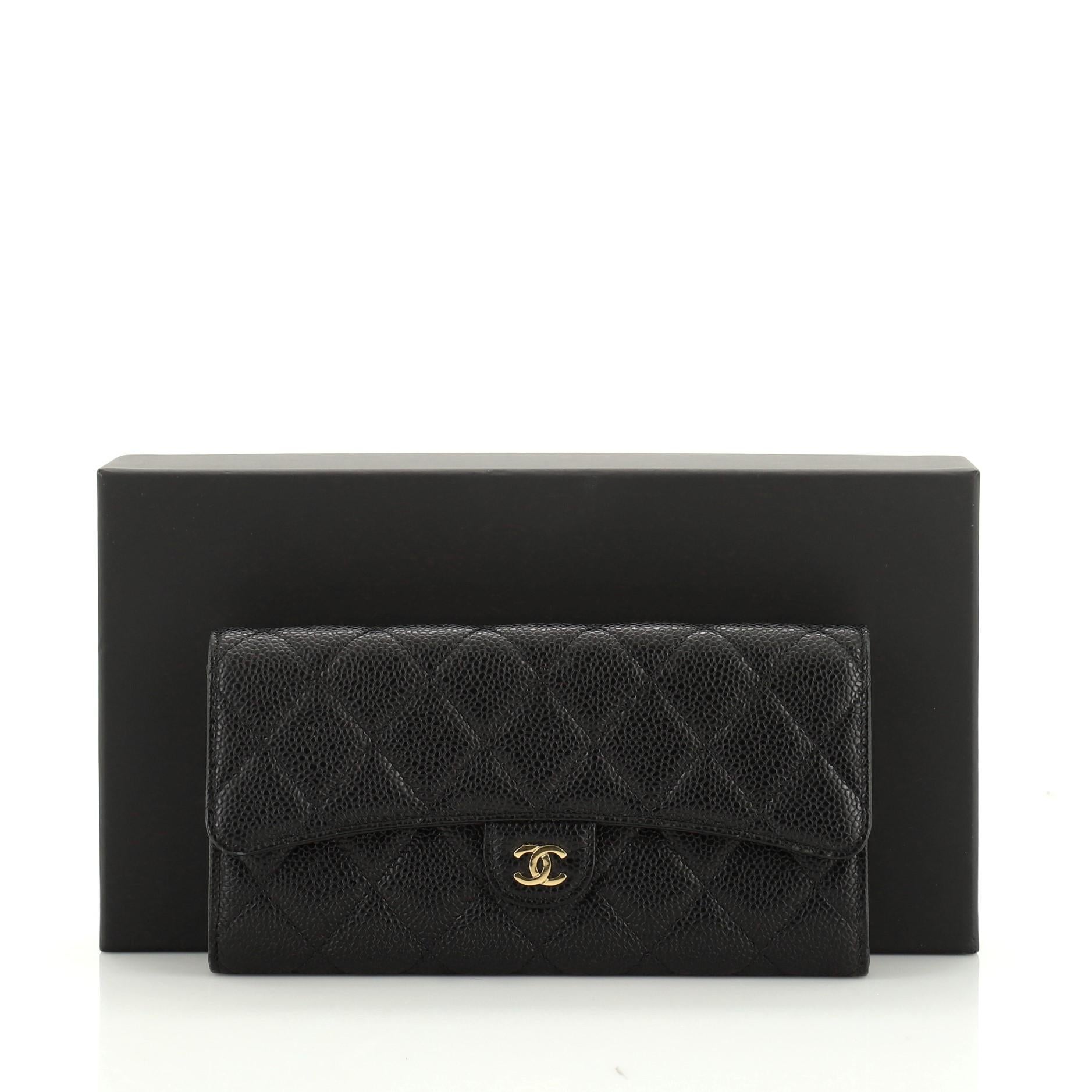 This Chanel CC Gusset Classic Flap Wallet Quilted Caviar Long, crafted from black quilted caviar leather, features interlocking CC logo, gusseted sides, and gold-tone hardware. Its snap button closure opens to a red fabric interior with multiple