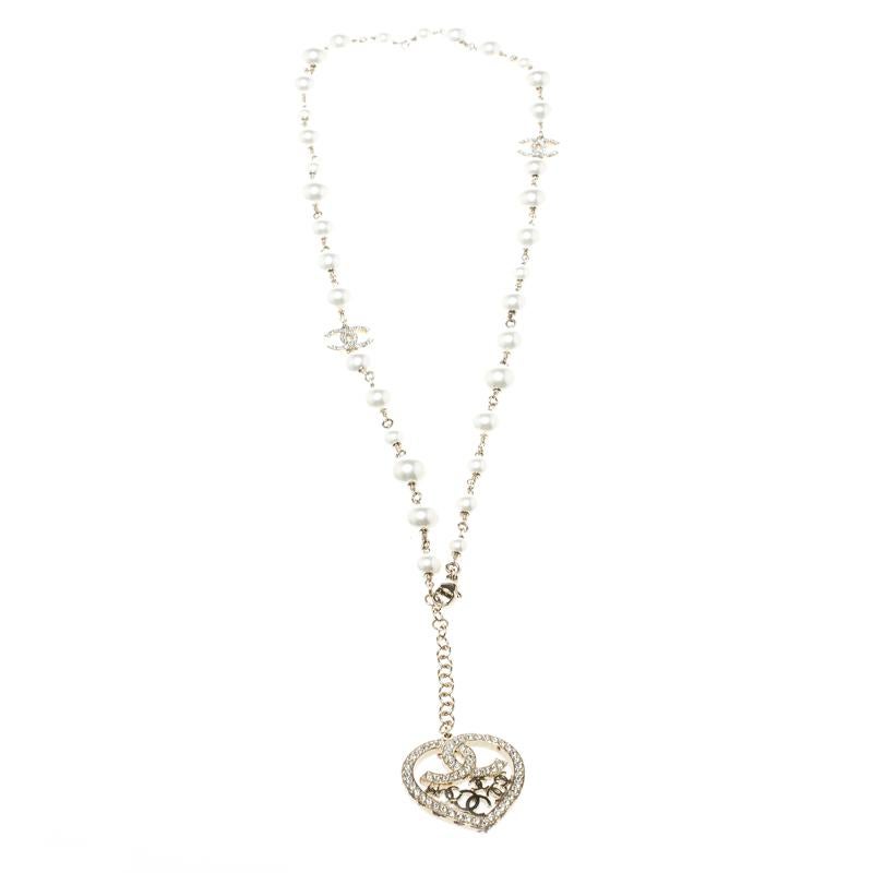 You are going to love this delicate and ultra-feminine necklace from Chanel. Crafted in gold-tone metal, this neckpiece features a string of faux pearls woven in a chain link. It comes with two crystal-embellished CC accent and an embellished