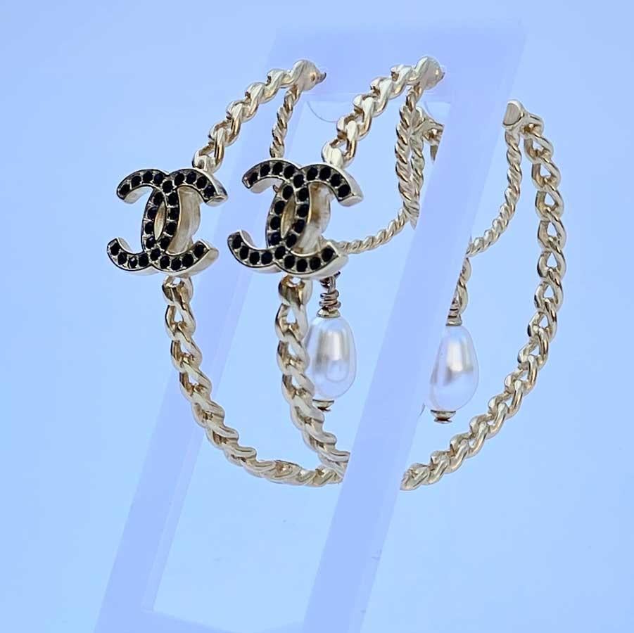 Studs composed of two circles: one twisted (the small one) and the other gourmet chain, a cc in black rhinestones and a pearly pearl in the shape of a pear.
Length : 5 cm, the CC is 1.5 cm long and the pearl 1.2 cm.
Delivered in their non original