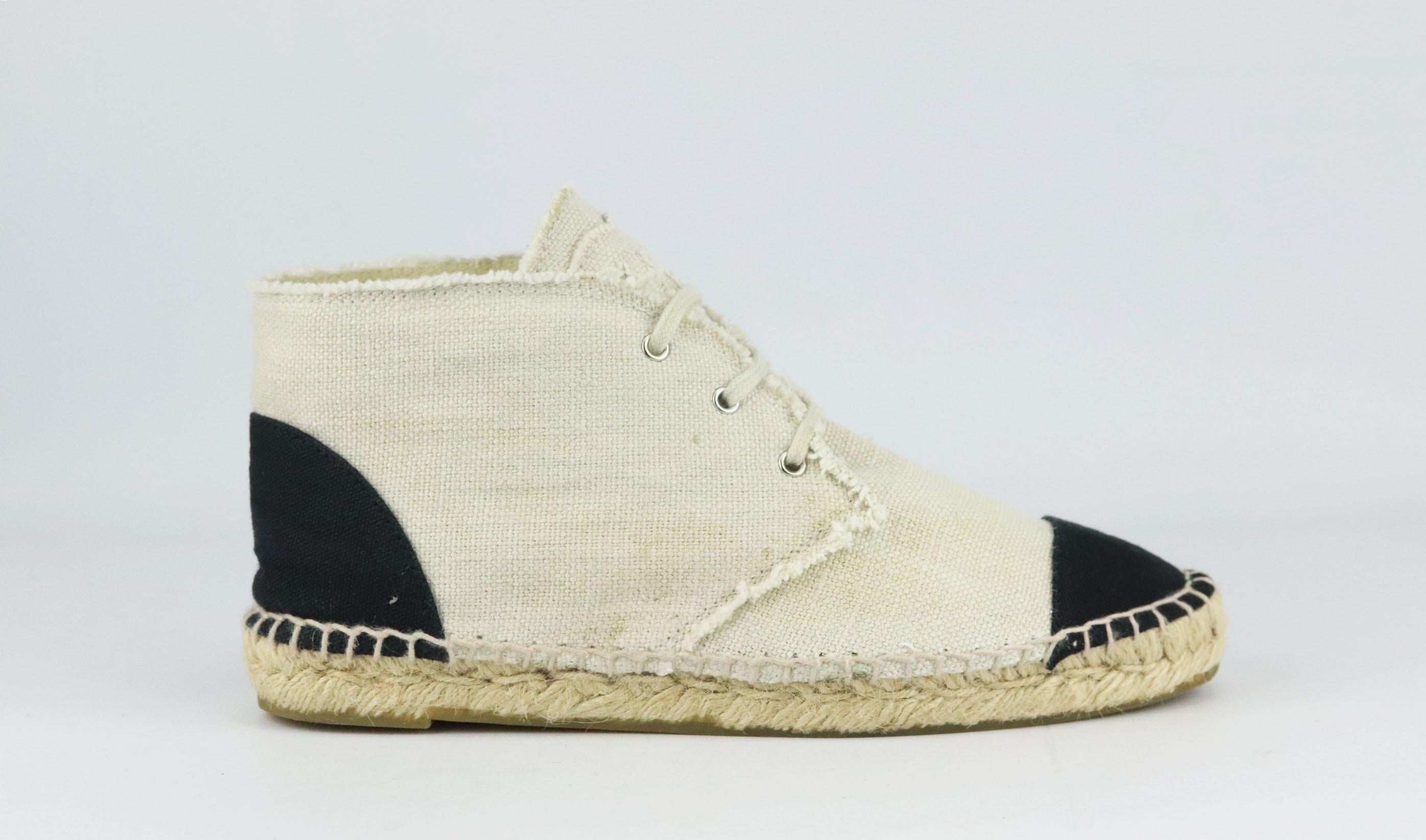 Chanel's lace-up espadrilles in cream linen, featuring the brand's trademark interlocking CC logo on the tongue in a matching frayed cream linen, they have a thick jute sole and a reinforced canvas toe which offers a comfortable and supportive