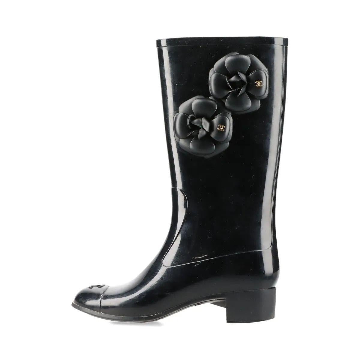 Les bottes de pluie en caoutchouc Chanel CC Logo Camellia, en noir, allient praticité et élégance iconique. Confectionnées en caoutchouc durable et brillant, ces bottes à hauteur de genou sont conçues pour résister au temps humide tout en conservant