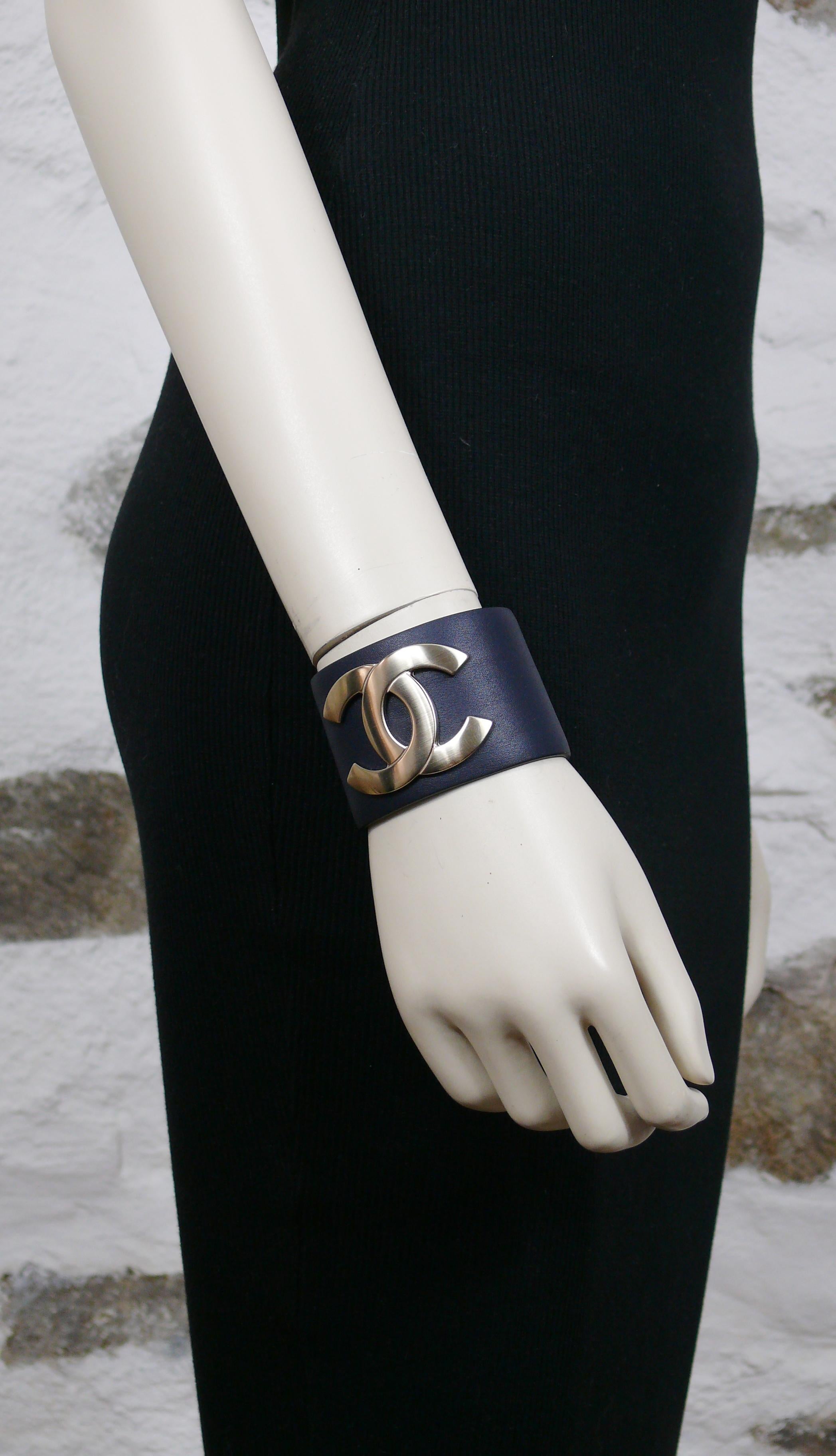 CHANEL dark navy blue wide leather cuff bracelet featuring a pale gold toned CC logo at the centre.

Exclusive Edition December 2017.

Laser mark CHANEL G18 C MADE IN ITALY.
Embossed on the leather EXCLUSIVE EDITION DECEMBER 2017.

Size mark reads :