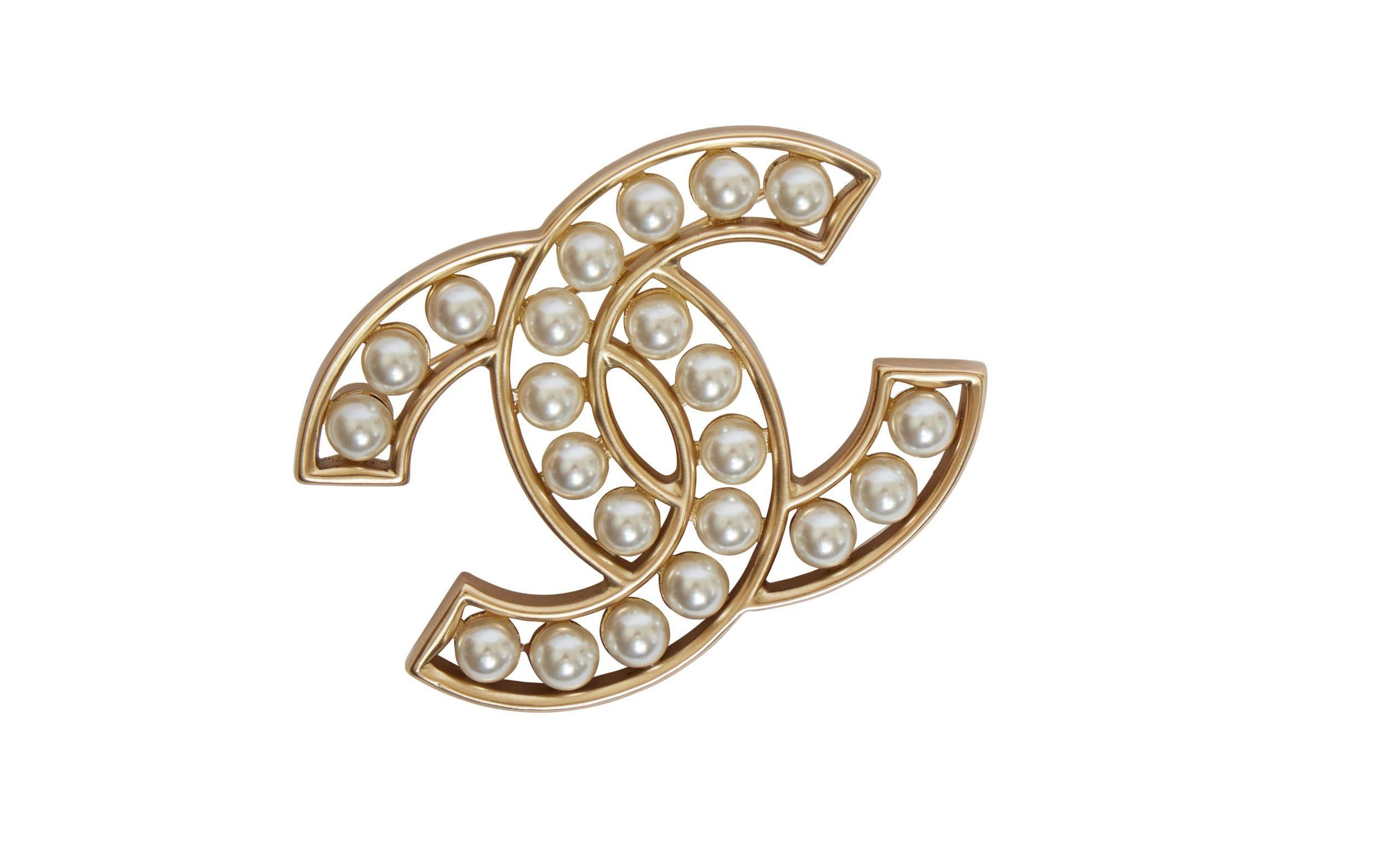 Golden Chanel CC logo pin with embedded pearls. On the back you can see a small plate with Chanel written on it. It is like new and goes perfectly with an everyday outfit as well as a night time outfit.
