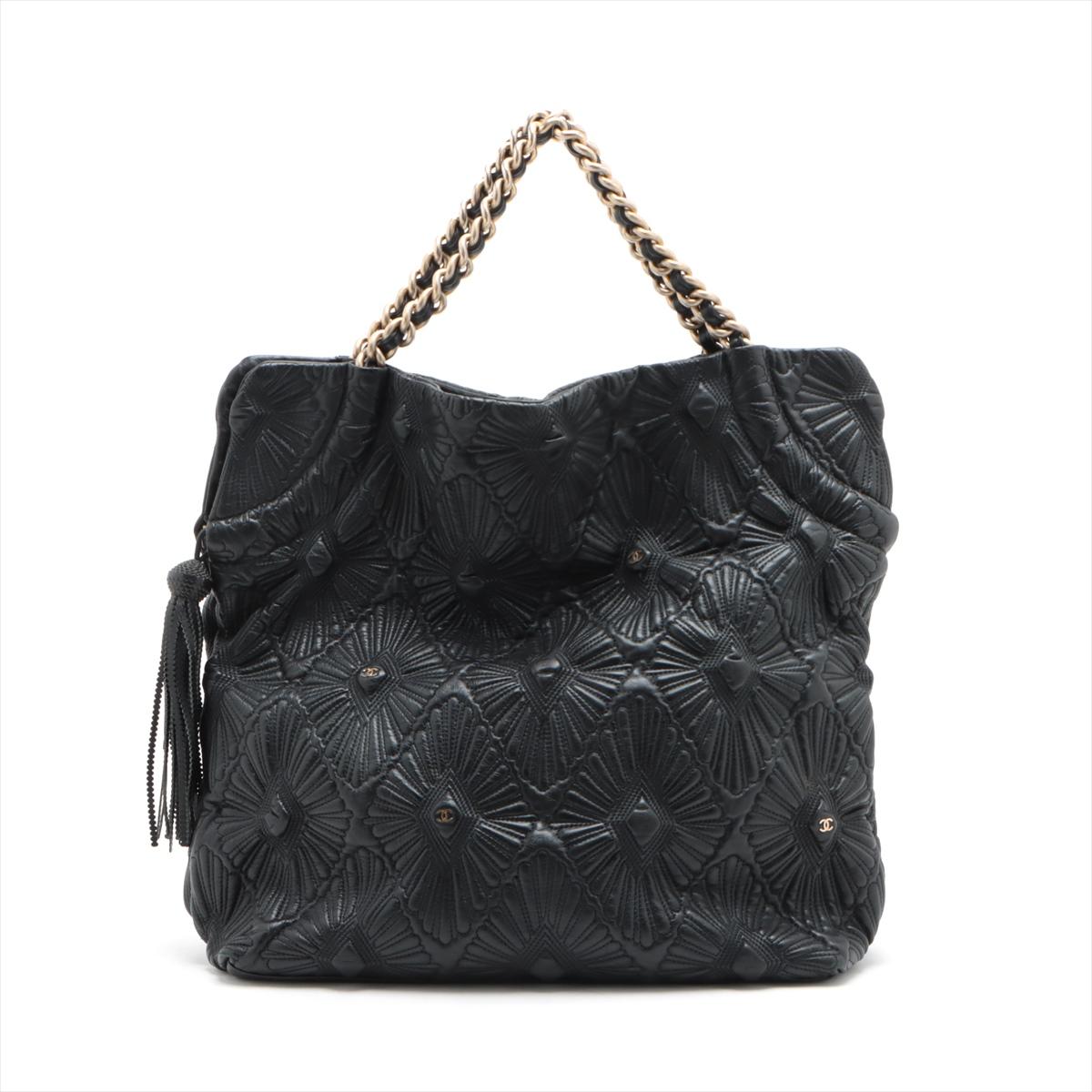The Chanel CC Logo Leather Chain Tassel Handbag in Black is a stunning embodiment of timeless elegance. Crafted from high-quality leather, the handbag features small iconic CC logo prominently displayed on the front like a button, a symbol of luxury