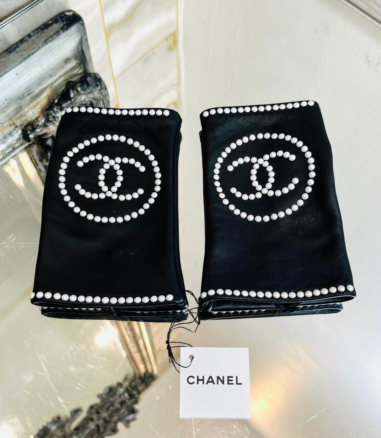 Brand New - Chanel 'CC' Logo Leather & Pearl Fingerless Gloves

Smooth, black gloves designed with white, faux pearl 'CC' logo to the front.

Featuring slip-on style and pearl lined edges.

From 2020 Collection.

Size – 7

Condition – Brand New,