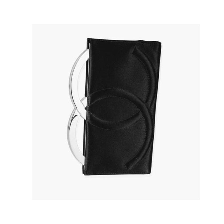 Exquisite rare small Chanel black satin silver logo CC letter clutch.  This evening clutch is made of satin with a large CC logo made of both silver hardware frame and black quilted satin.  Black CC monogram microfiber interior lining featuring an
