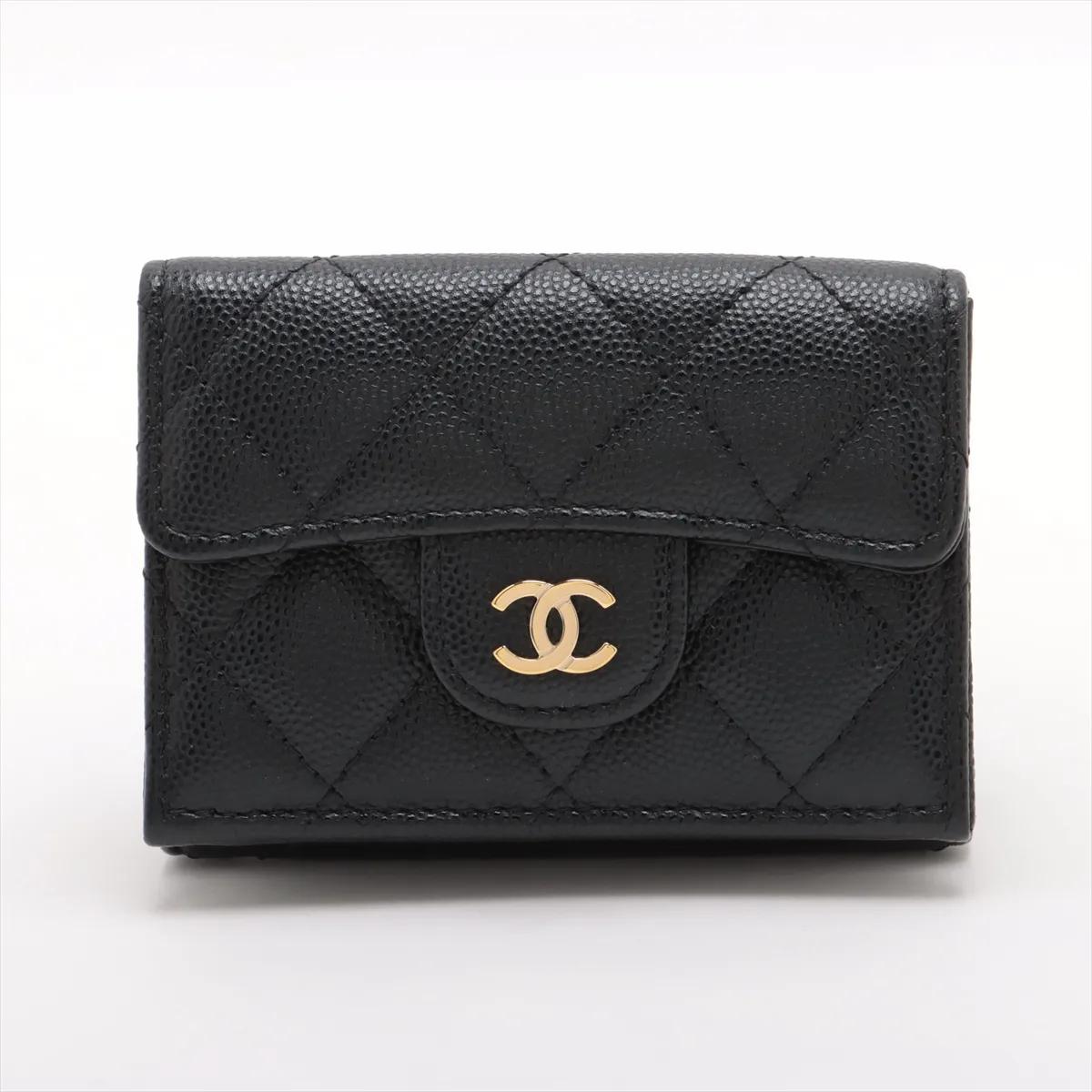 Il portafoglio Chanel CC Logo Matelassé Caviar Skin Compact Wallet in nero è un accessorio raffinato e pratico realizzato con la tipica pelle di caviale del marchio, nota per la sua texture lussuosa e la sua durata. Con il classico design matelassé