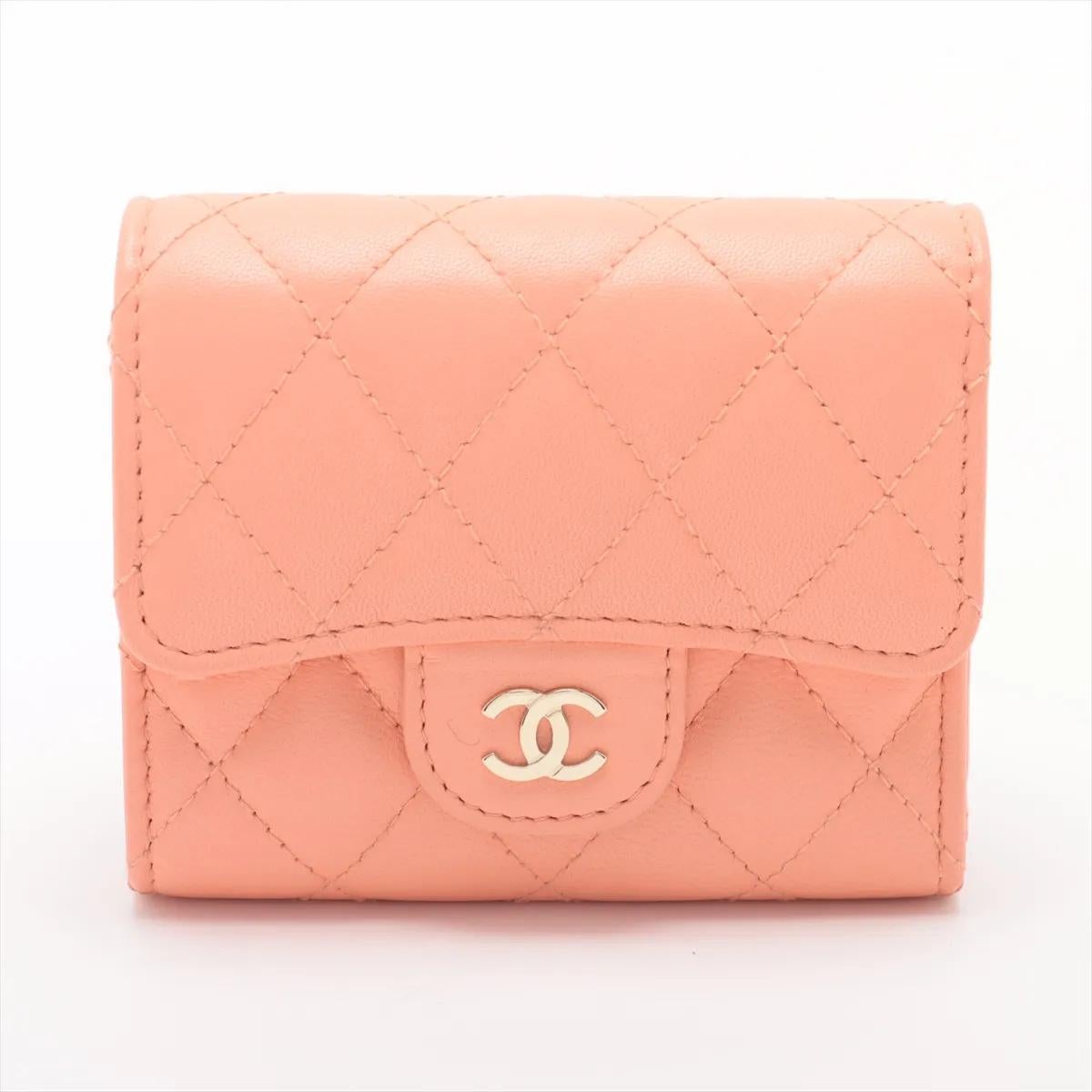 Il portafoglio compatto Chanel CC Logo Matelassé in pelle d'agnello rosa salmone è un'affascinante miscela di eleganza e funzionalità. Realizzata in lussuosa pelle d'agnello, presenta l'inconfondibile trapuntatura a rombi che emana l'intramontabile