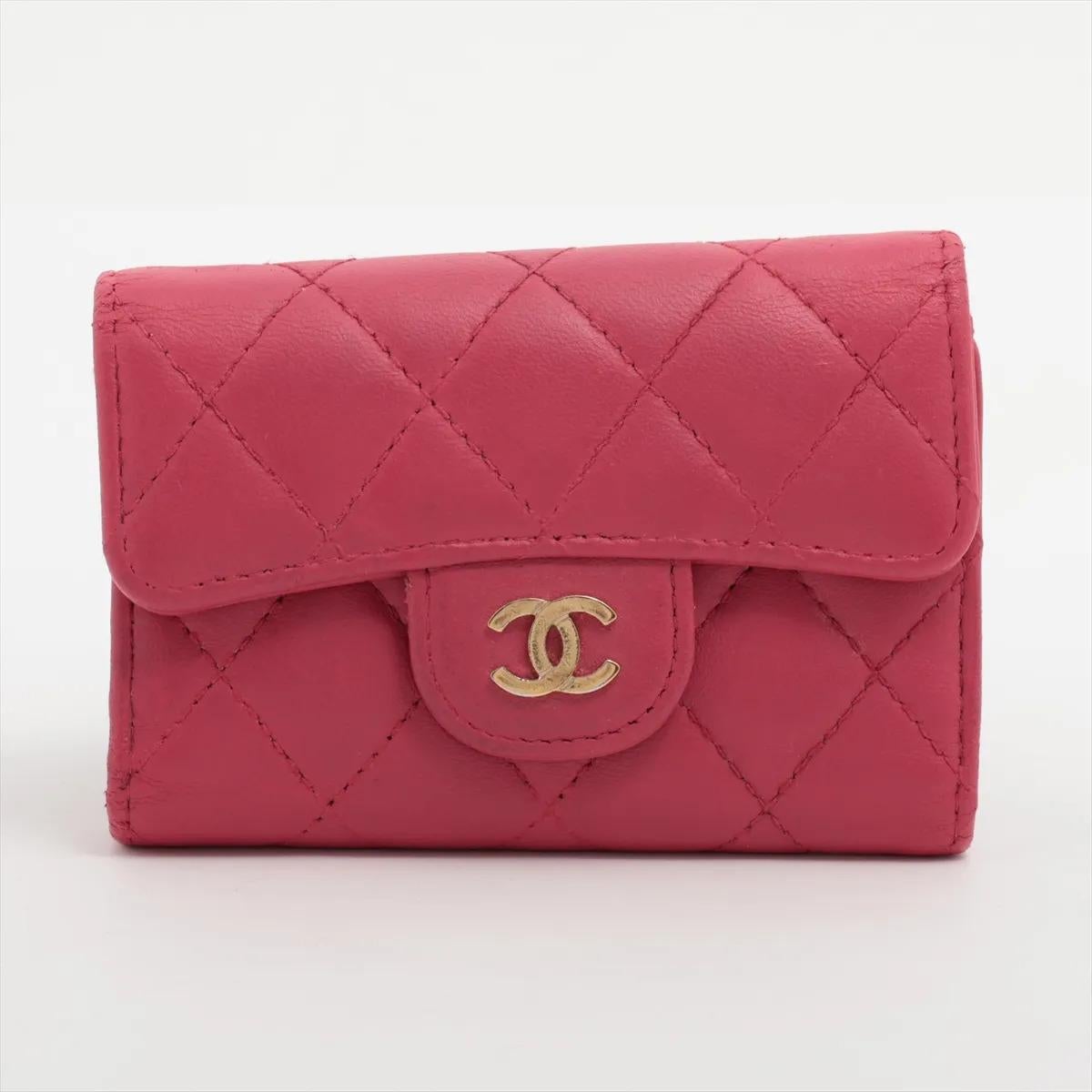 The Chanel CC Logo Matelassé Lambskin Key Case in red showcases the brand's signature elegance and craftsmanship. Made from luxurious lambskin leather, it features the iconic diamond-quilted matelassé pattern and a polished gold-tone CC logo on the