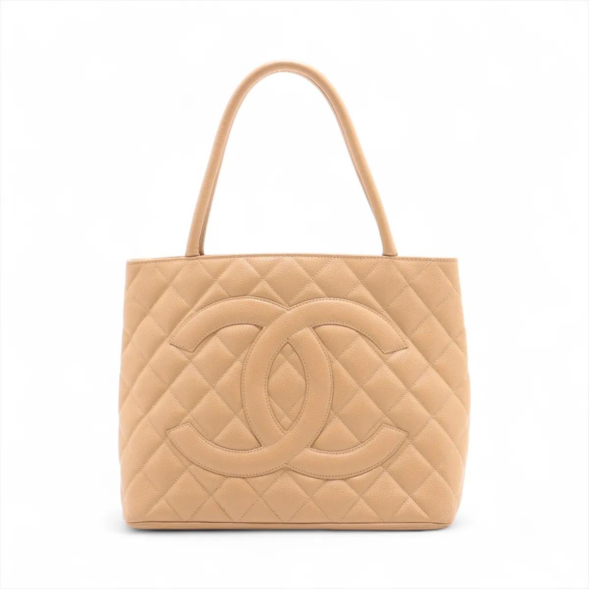 The Chanel CC Logo Re-release Caviar Skin Tote Bag in Beige is a timeless and elegant piece that highlights the house’s signature craftsmanship. Made from durable and luxurious caviar leather, the tote features a structured silhouette that exudes