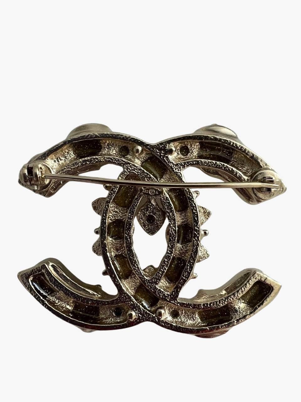 Chanel brooch in the iconic form of interlocking CC logo. 
Decorated with resin cabochons in silver and yellow-tone colors.
Signed. 
Mark: A12 A  
Year: 2012
Condition: very good, light scratches throughout metal.
........Additional information