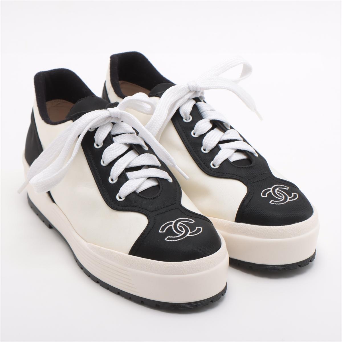 The Chanel CC Logo Sneakers in White and Black are a stylish and contemporary addition to any footwear collection. The sneakers feature a sleek white upper contrasted with black accents, creating a classic and versatile look. The iconic CC logo is