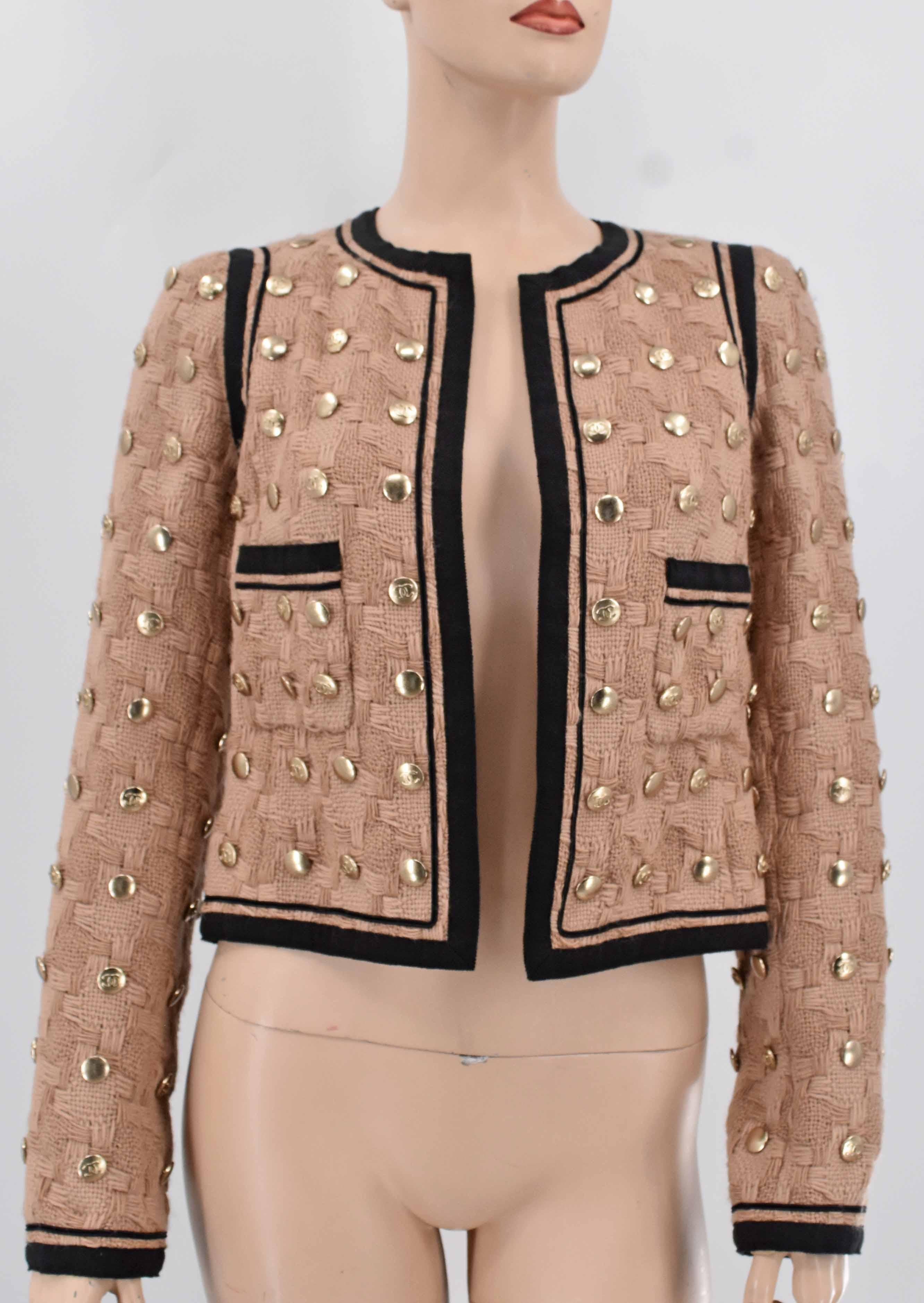 Chanel rare to find studded tweed jacket adorned with Chanel interlocking CC logo throughout. It is adorned with two front faux pockets, weighted chain at hem. It is fully lined. This unique piece is from Chanel Fall 2008 collection. It is new