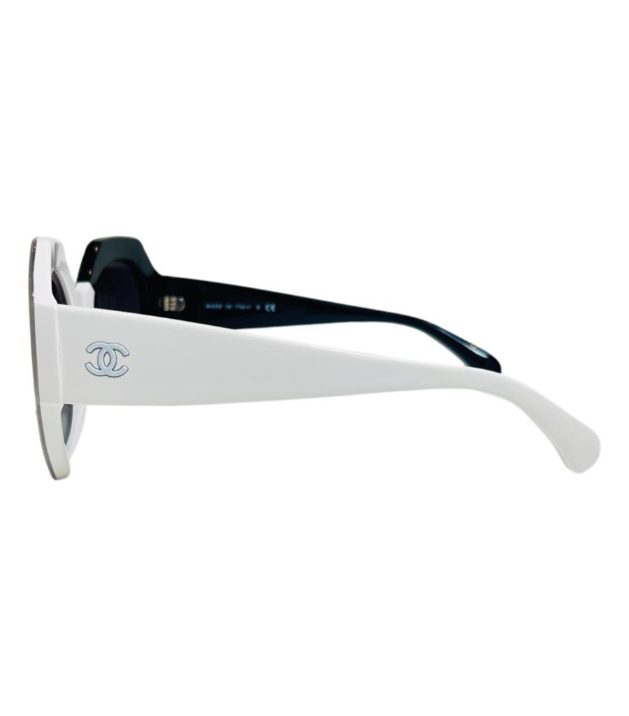 Chanel 'CC' Logo-Sonnenbrille

Schwarze und weiße Sonnenbrille in Sechseckform mit schwarzen Gläsern.

Mit dicken Rändern und weißem 