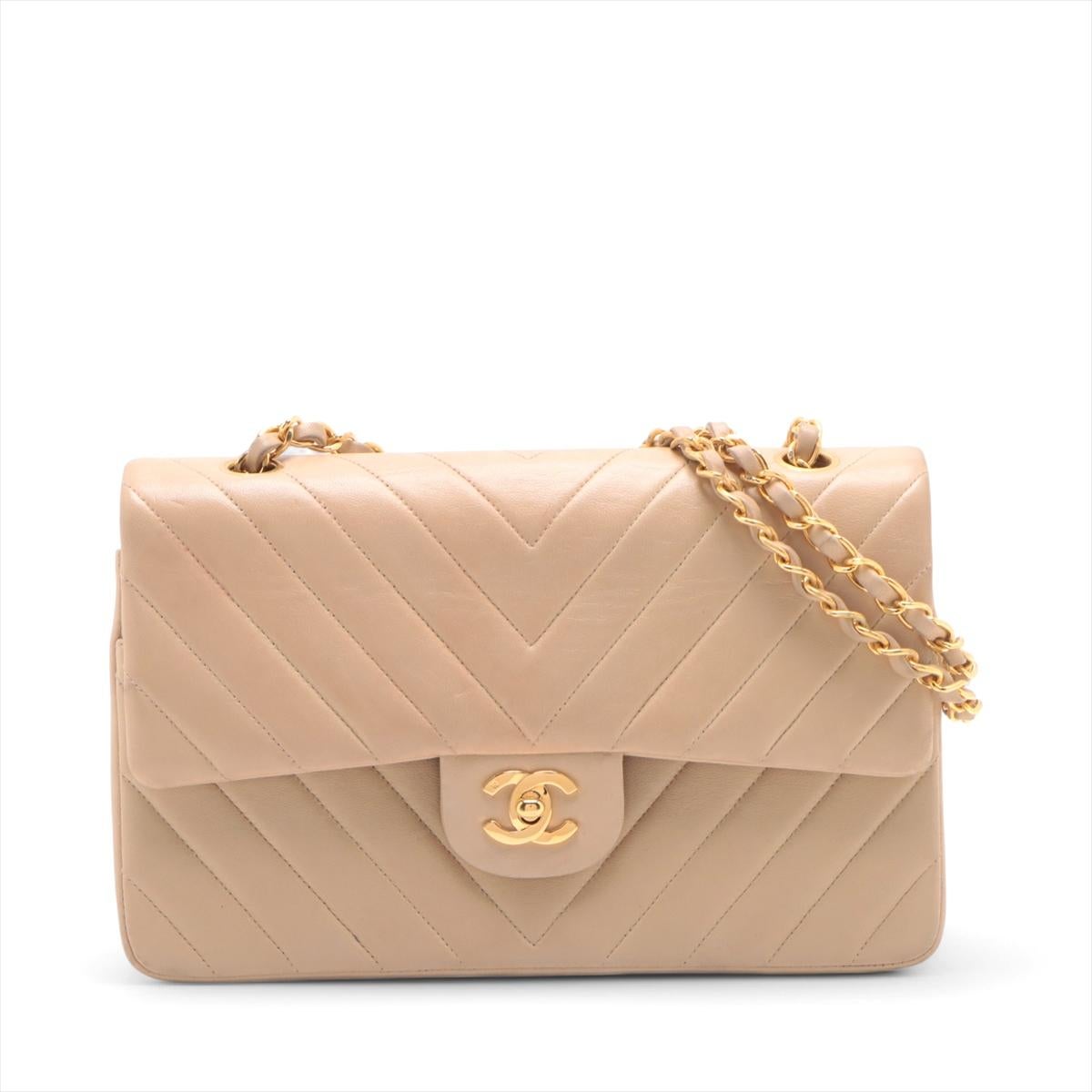 The Chanel CC Logo V Stitch Lambskin Double Flap Double Chain Bag in Beige is a timeless and elegant piece crafted from luxurious lambskin leather. Featuring signature V-shaped stitching and the iconic CC logo on the front flap, the classic bag