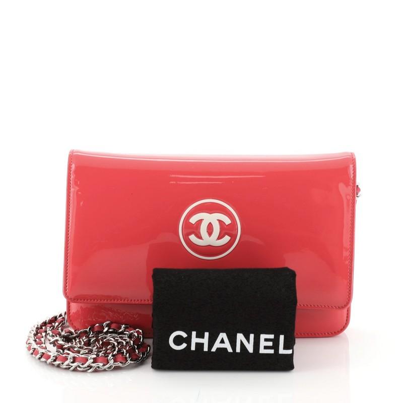 This Chanel CC Logo Wallet on Chain Patent, crafted in pink patent leather, features a CC logo design, woven-in leather chain strap, and silver-tone hardware. Its hidden magnetic snap closure opens to a pink fabric and leather interior with multiple