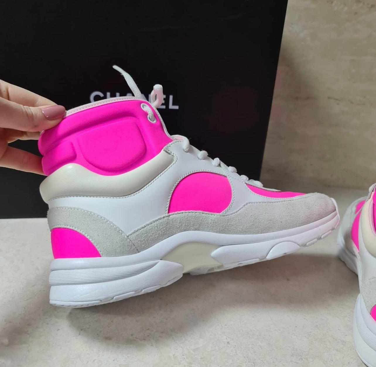 Worn by Lil Wayne. These Chanel High-Top Sneakers feature a white leather and neon pink neoprene textile upper; ivory suede overlays; white leather CC logo patch on the side; tonal lace front; & tonal mid and outsole.

Sz.38

Comes with original box.