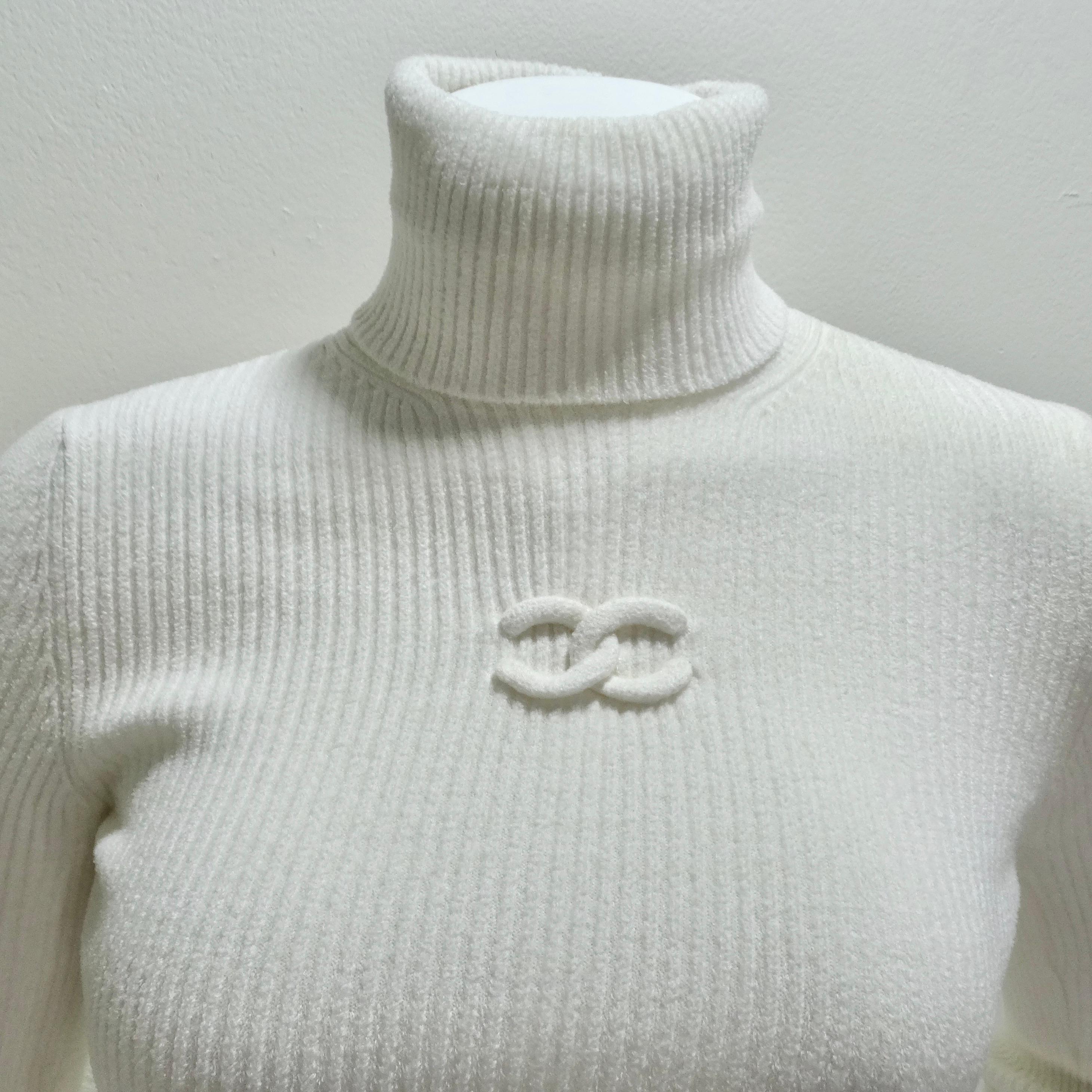 Introducing the epitome of timeless elegance - the Chanel CC Logo White Rib Knit Turtleneck. This classic, long-sleeve turtleneck is more than just a piece of clothing; it's a statement of refined luxury. Crafted from a sumptuously stretchy and soft