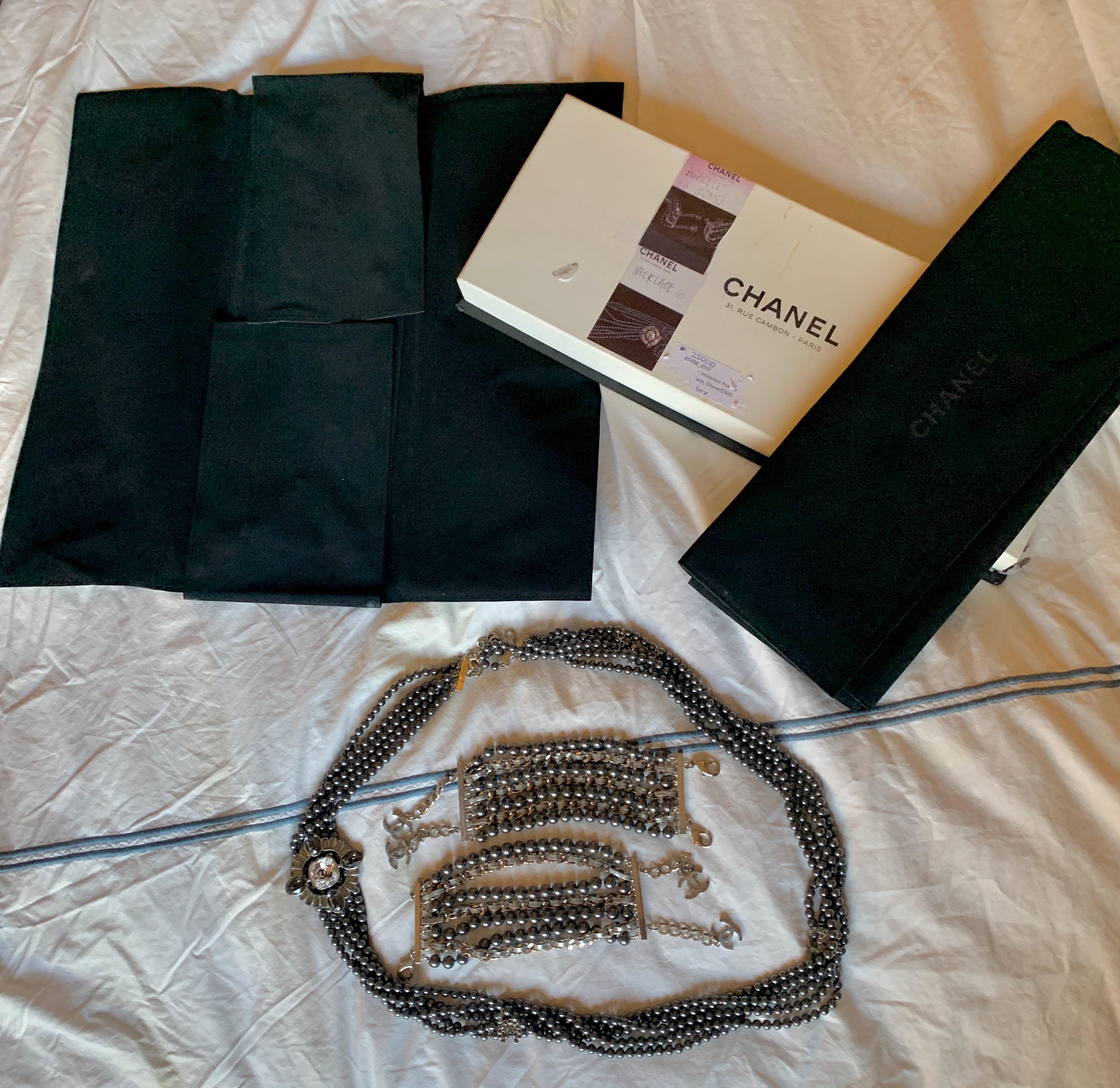This is a very rare and magnificent Chanel Parure with a 38 inch Chanel CC Multistrand Black Faux Pearl and Rhinestone Necklace and Two Bracelets with the original 2 Chanel pouches and box.
The statement necklace and bracelets feature faux Black