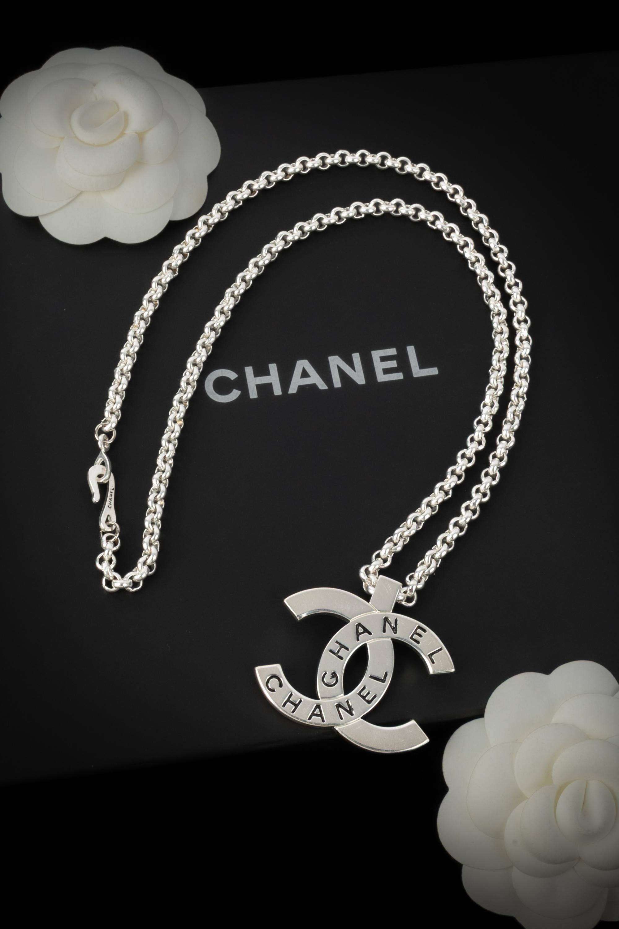 CHANEL - (Made in France) Lange silberne Metallkette mit einem cc-Anhänger. Spring-Summer Collection 1998 unter der künstlerischen Leitung von Karl Lagerfeld.

Bedingung:
Sehr guter Zustand

Abmessungen:
Länge: 63 cm - Anhänger: 3,5 cm x 4,5