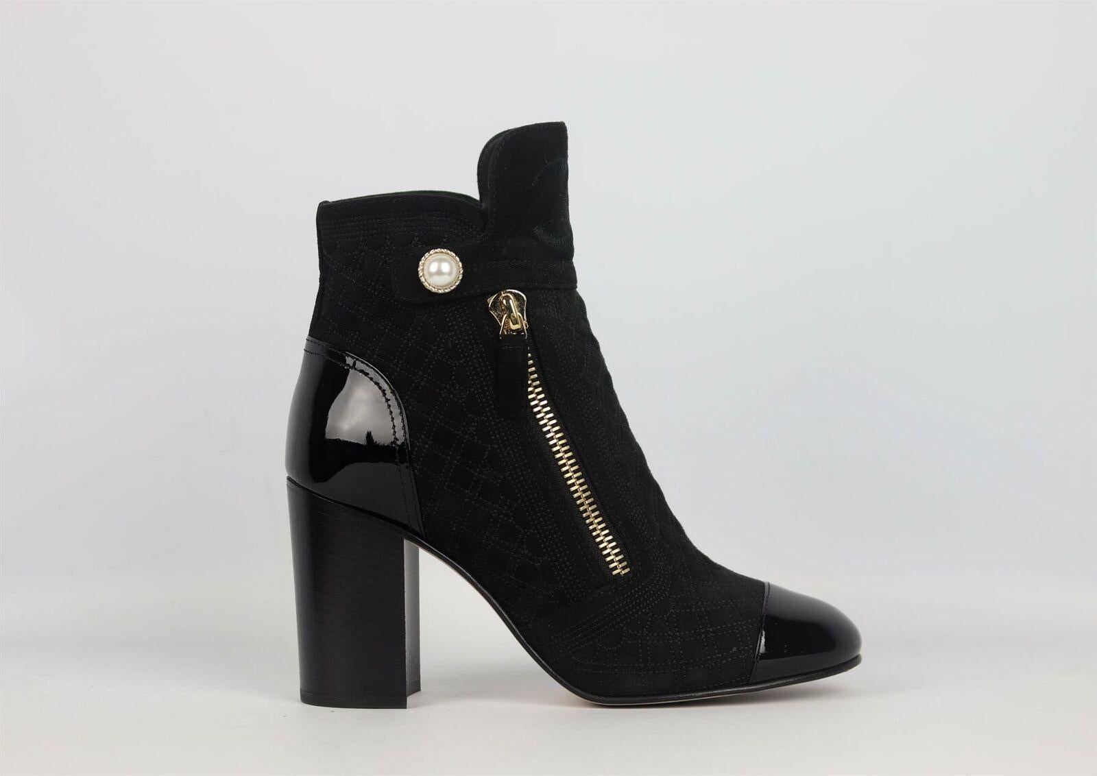 These beautiful Chanel ankle boots have been crafted in Italy from black quilted suede and patent leather trim with delicate faux-pearl detail flap at the side with zip fastening, they are finished with an embroidered CC and block heel. 
Heel