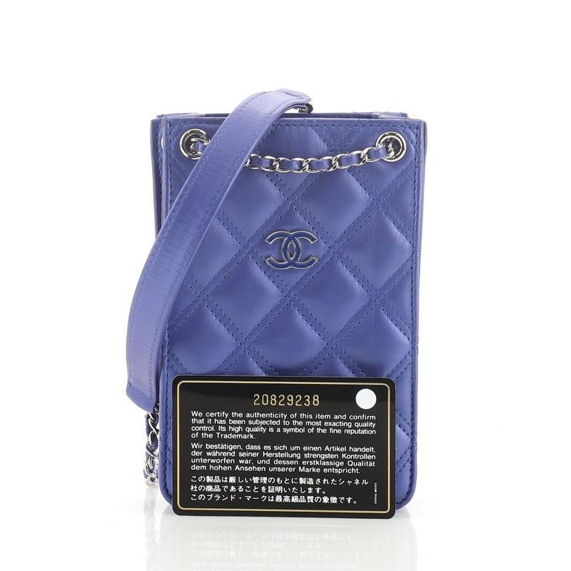 This Chanel CC Phone Holder Crossbody Bag Quilted Lambskin, crafted in blue quilted lambskin leather, features woven-in leather chain strap with leather pad, front CC logo detail, expandable sides and silver-tone hardware. It opens to a blue fabric