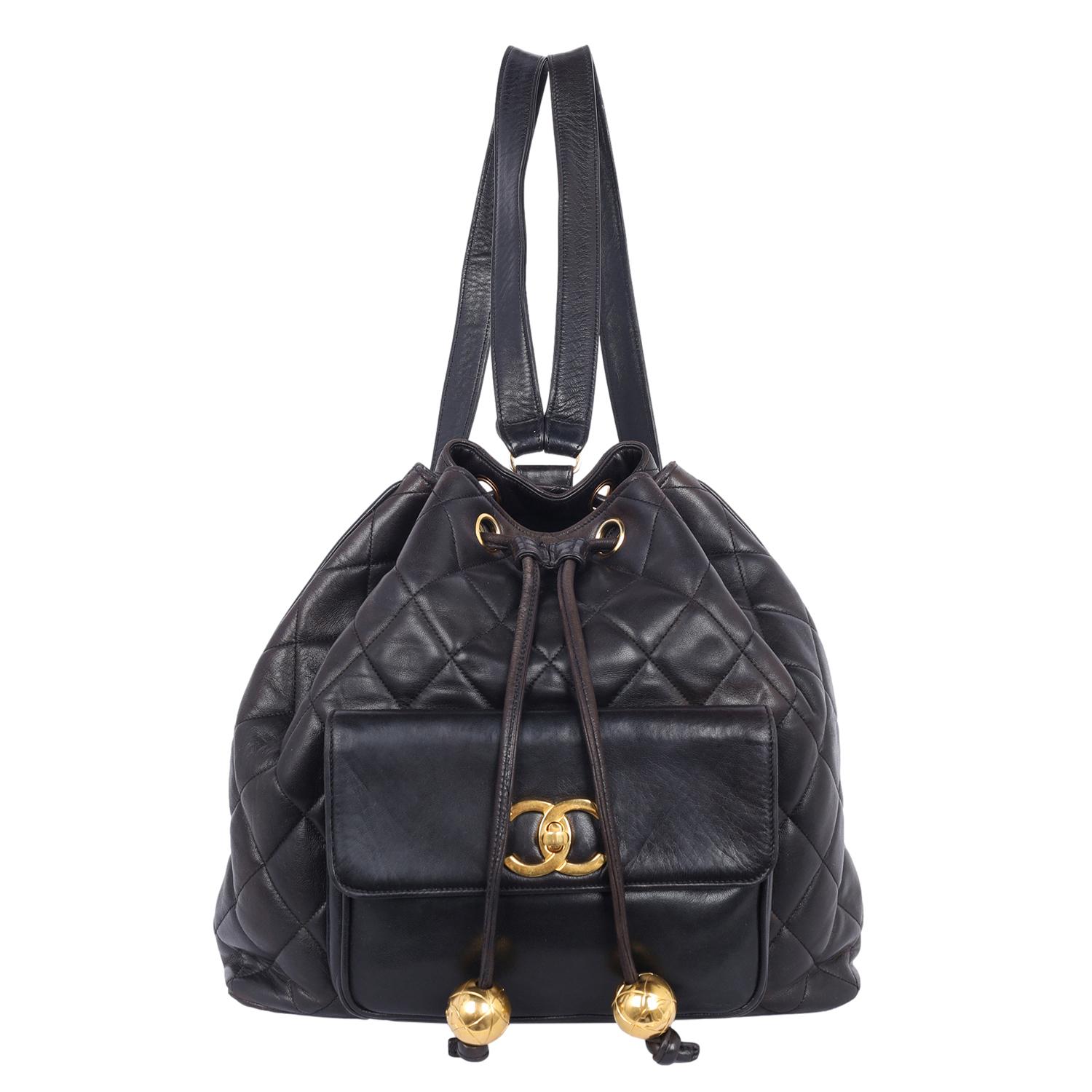 Authentic, pre-loved Chanel vintage black quilted lambskin leather backpack. Features: Signature quilted lambskin leather, drawstring closure, 24 kt gold plated hardware, classic CC turn-lock pocket closure, two main interior zippered pockets, two