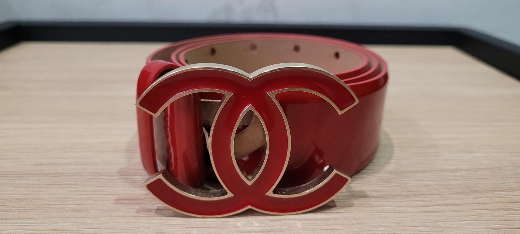 Der Chanel Gürtel ist aus rotem Lackleder gefertigt.
Das elegante Design wird durch die charakteristische CC-Schnalle auf der Vorderseite vervollständigt, die mit 5 Löchern verstellbar ist, mindestens 69 cm, maximal 79 cm. Länge: 88