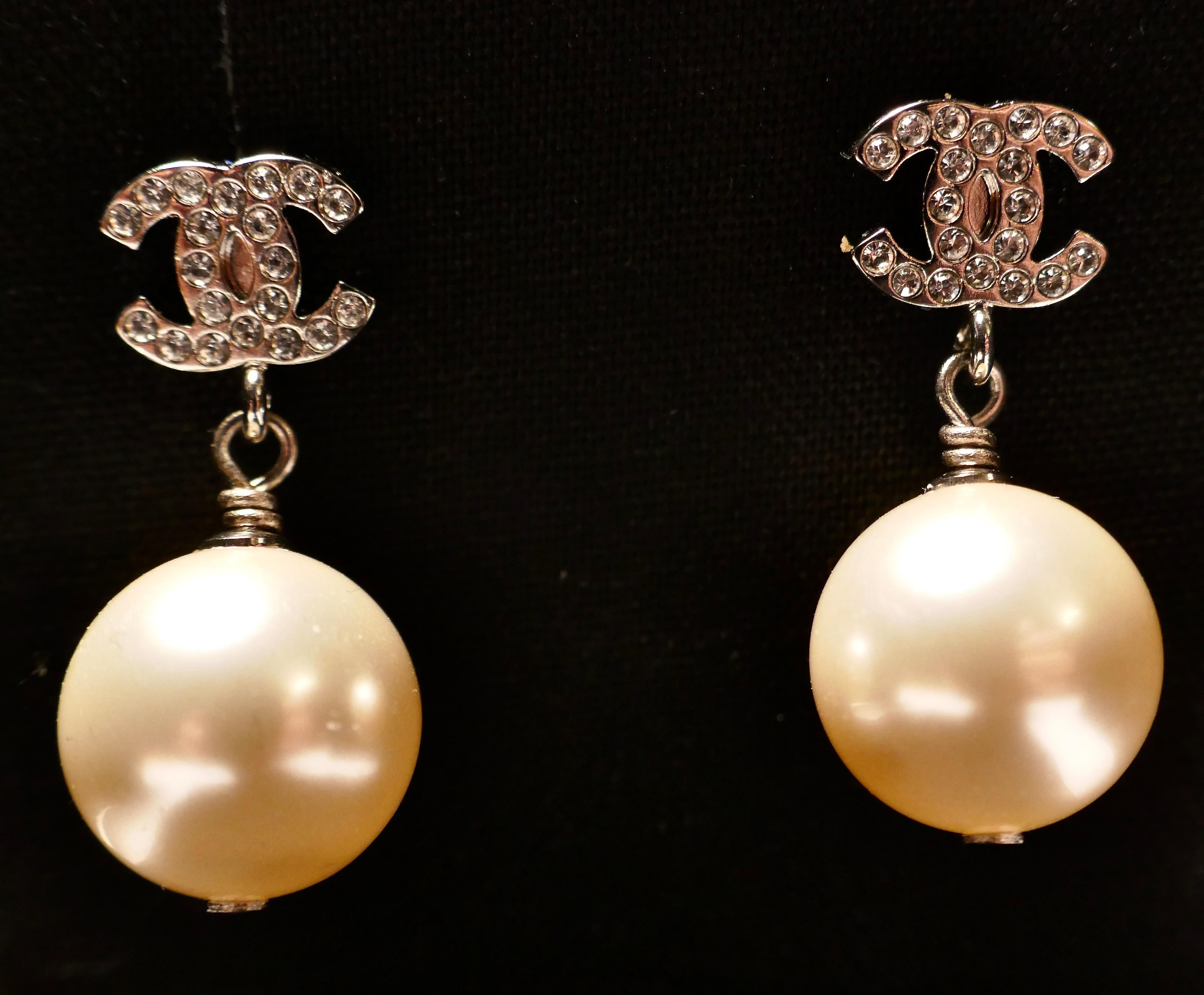 Chanel CC Rhinestone Crystal Earrings with Large Pearl Pendant Drop

A fantastic pair of earrings guaranteed Original Chanel, 1” drop for pierced ears (original Black presentation box and pouch)
The earrings are in Silver coloured metal with large